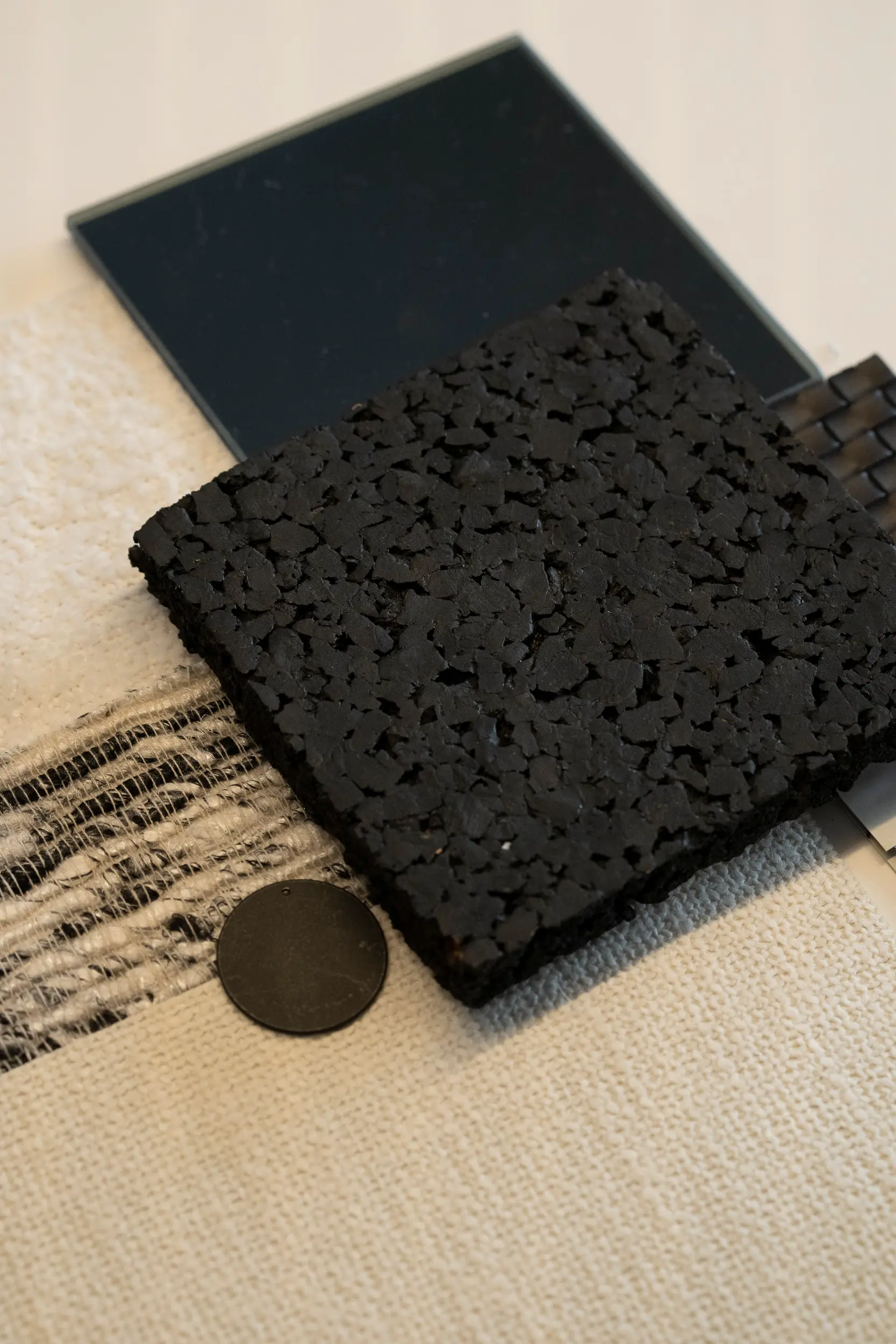 Amostras de materiais e tecidos em tons neutros e preto para um projeto de interiores.