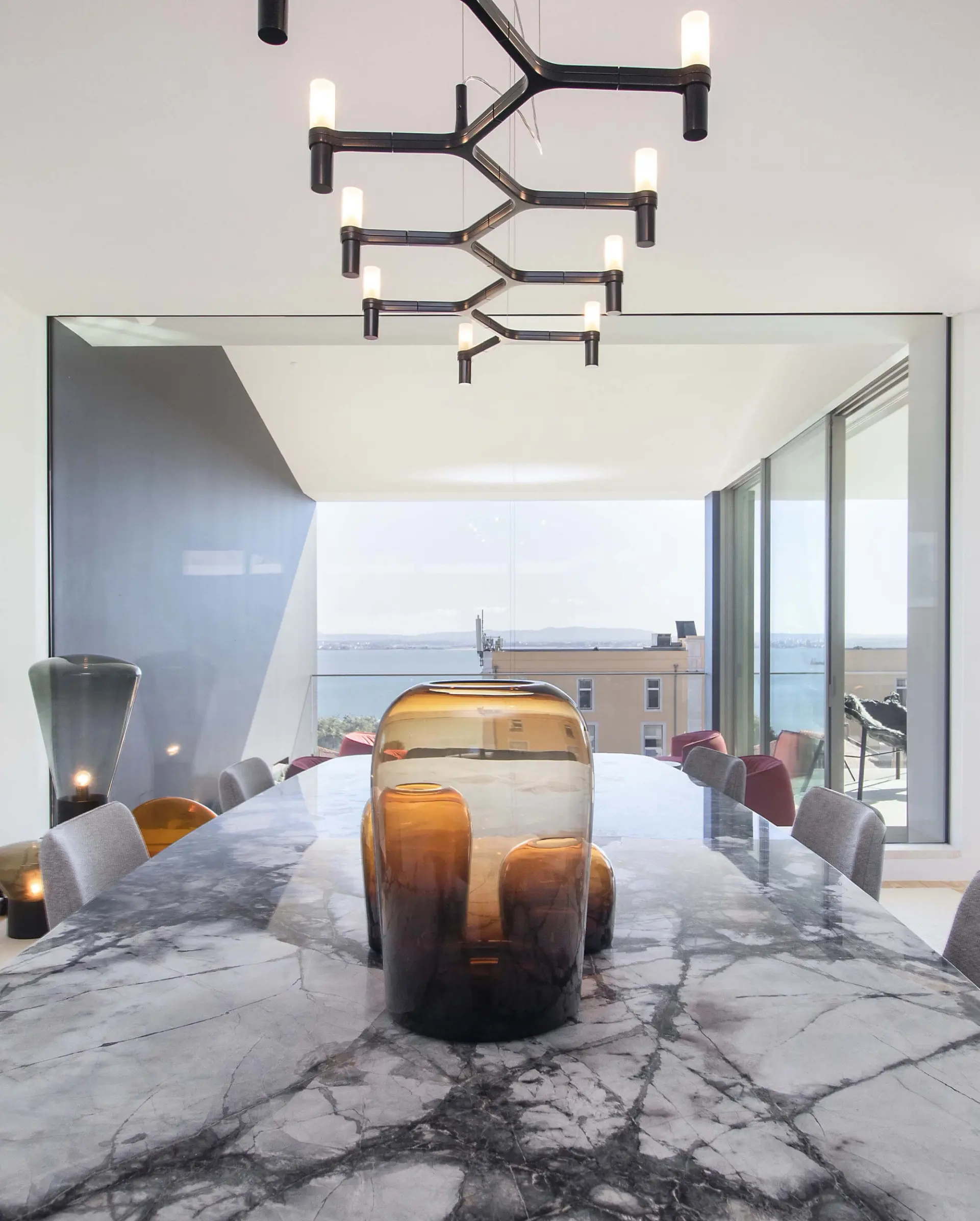 Sala de jantar com mesa Arketipo em mármore Moon Grey, pendente Nemo Crown Plena e vista do Tejo — design de interiores de luxo, Lisboa, Atelier Renata Santos Machado