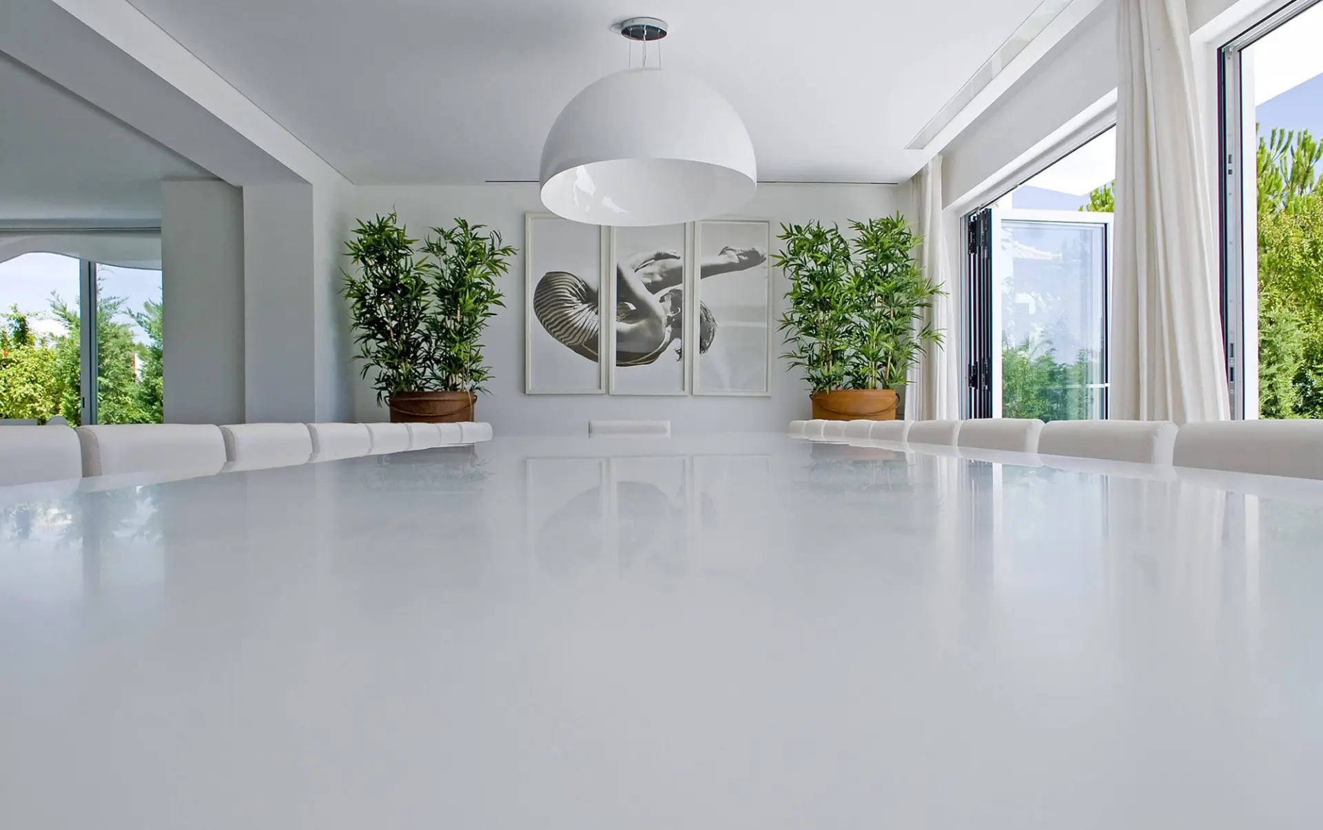 Sala de jantar branca com candeeiro em cúpula e tríptico fotográfico a preto e branco — design de interiores de luxo Tróia, Setúbal