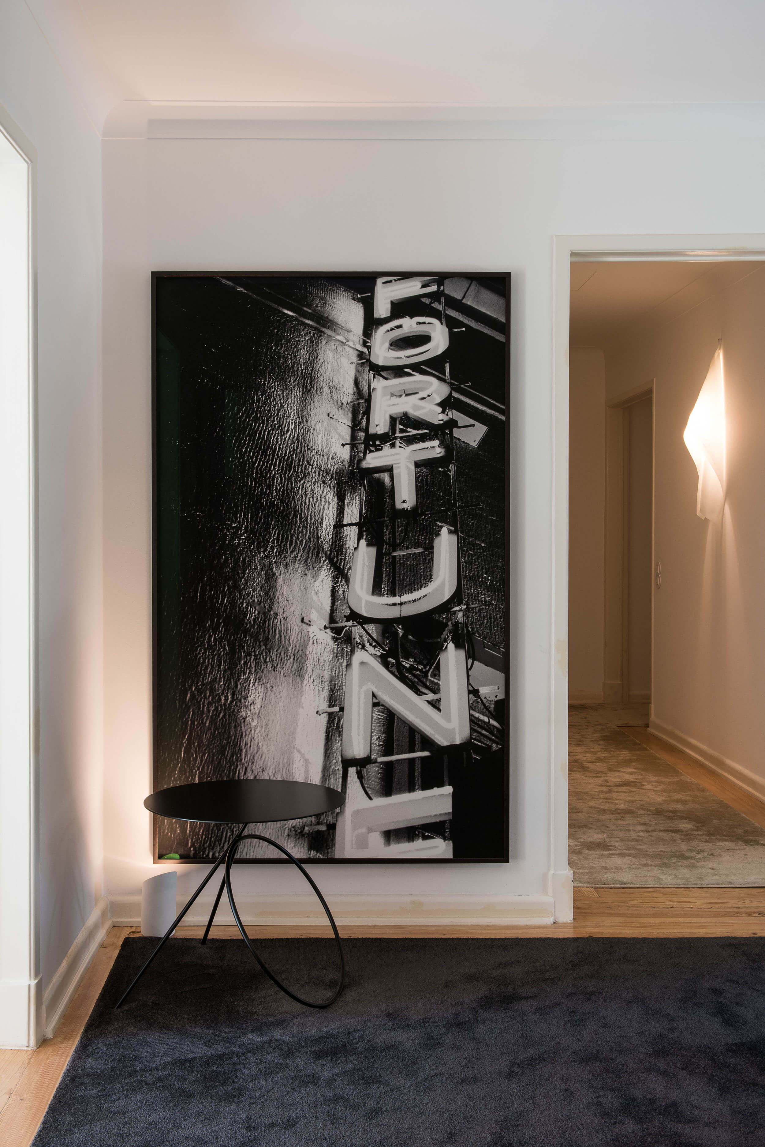 Hall de entrada com fotografia Fortune de João Penalva e tapete preto sobre parquet — design de interiores de luxo, Avenidas Novas, Lisboa, Atelier Renata Santos Machado