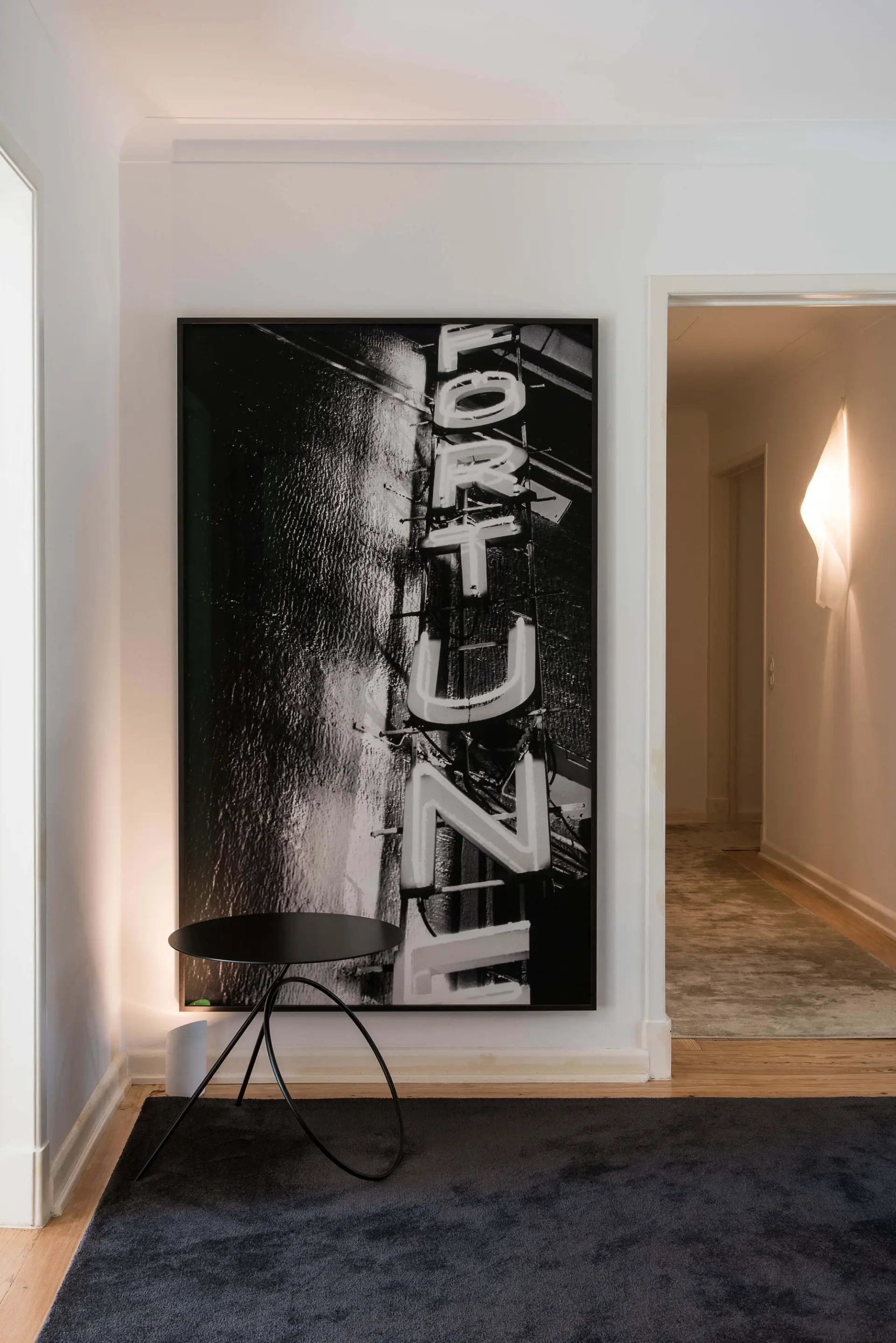 Hall de entrada com fotografia Fortune de João Penalva e tapete preto sobre parquet — design de interiores de luxo, Avenidas Novas, Lisboa, Atelier Renata Santos Machado