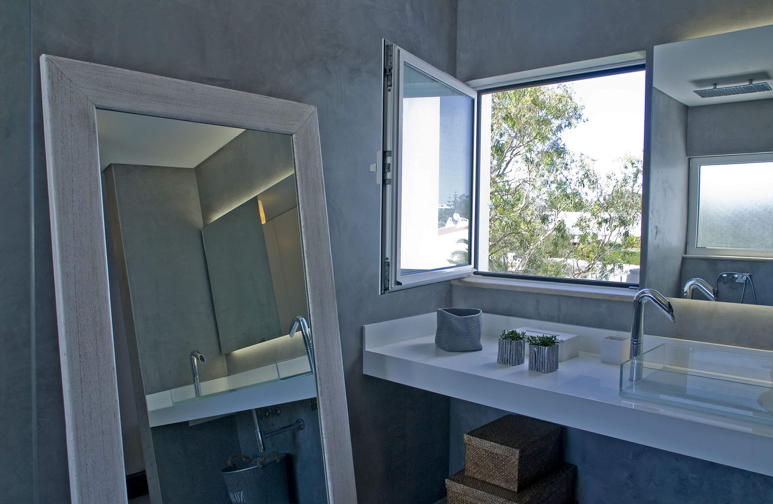 Casa de banho em microcimento com bancada suspensa branca e espelho de chão em madeira — design de interiores de luxo Tróia, Setúbal