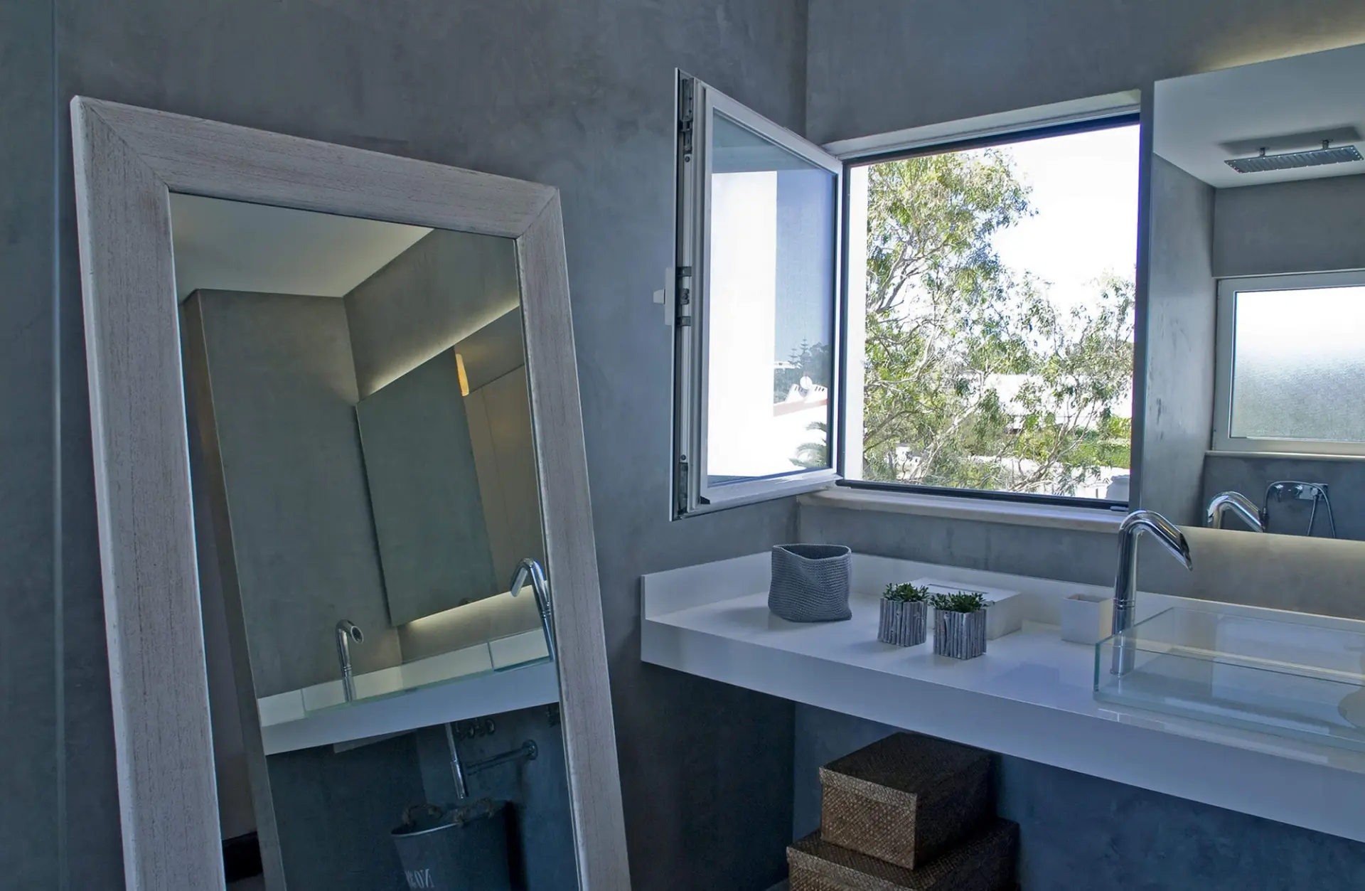 Casa de banho em microcimento com bancada suspensa branca e espelho de chão em madeira — design de interiores de luxo Tróia, Setúbal