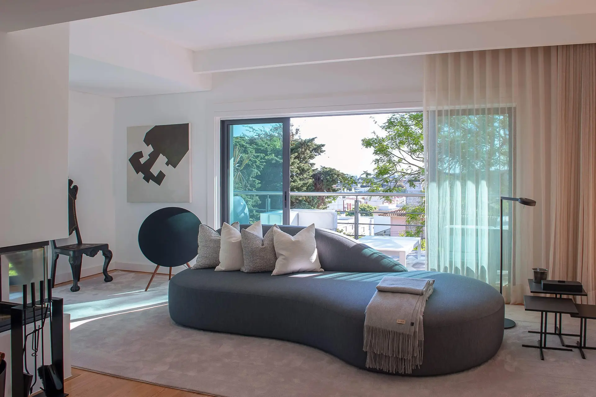 Sala de estar contemporânea com design minimalista e luz natural. Resultado de remodelação de apartamento de luxo com projeto rigoroso