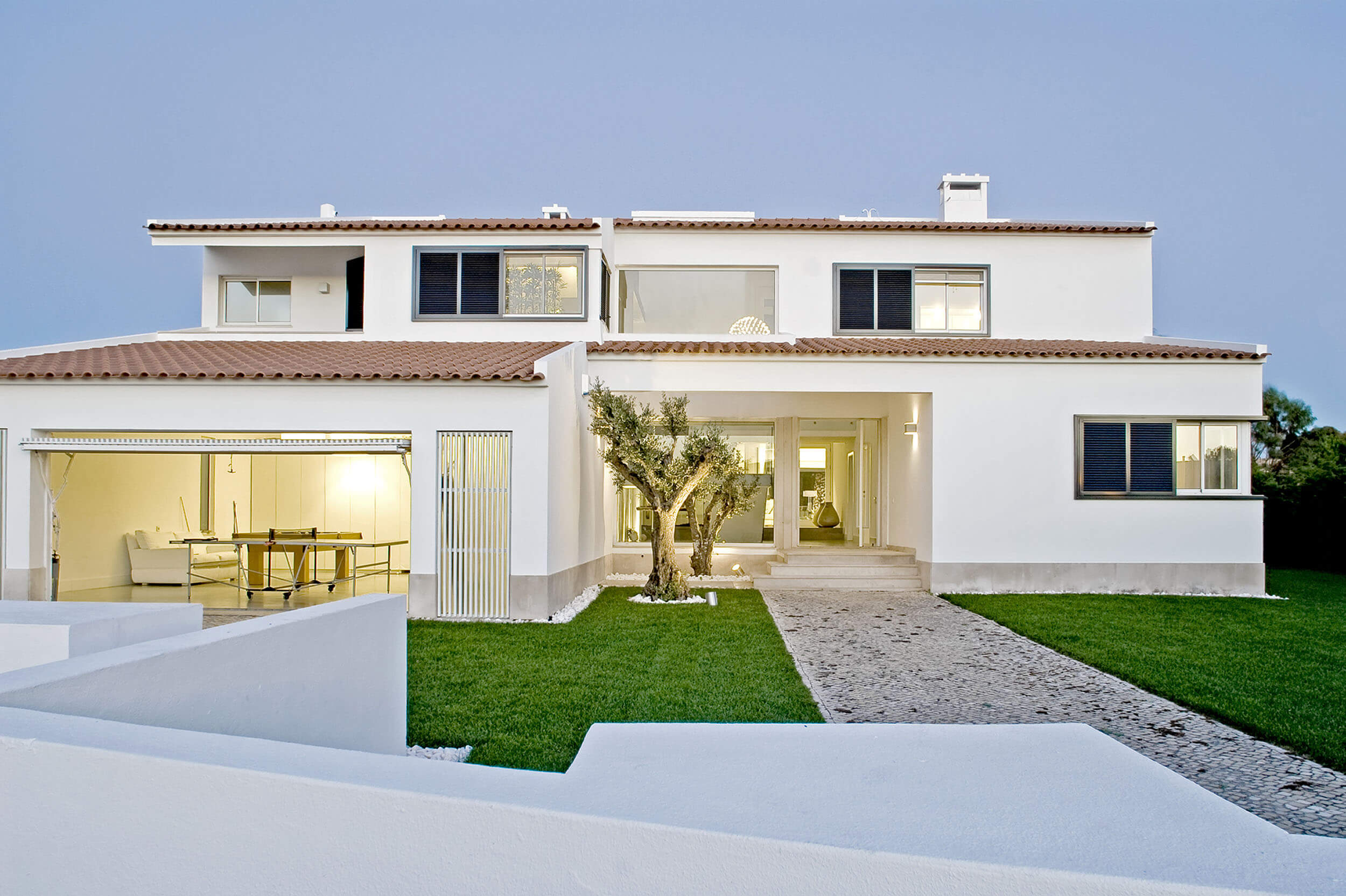 Fachada de moradia branca com telha de barro, caminho em calçada e relvado — design de interiores de luxo Tróia, Setúbal
