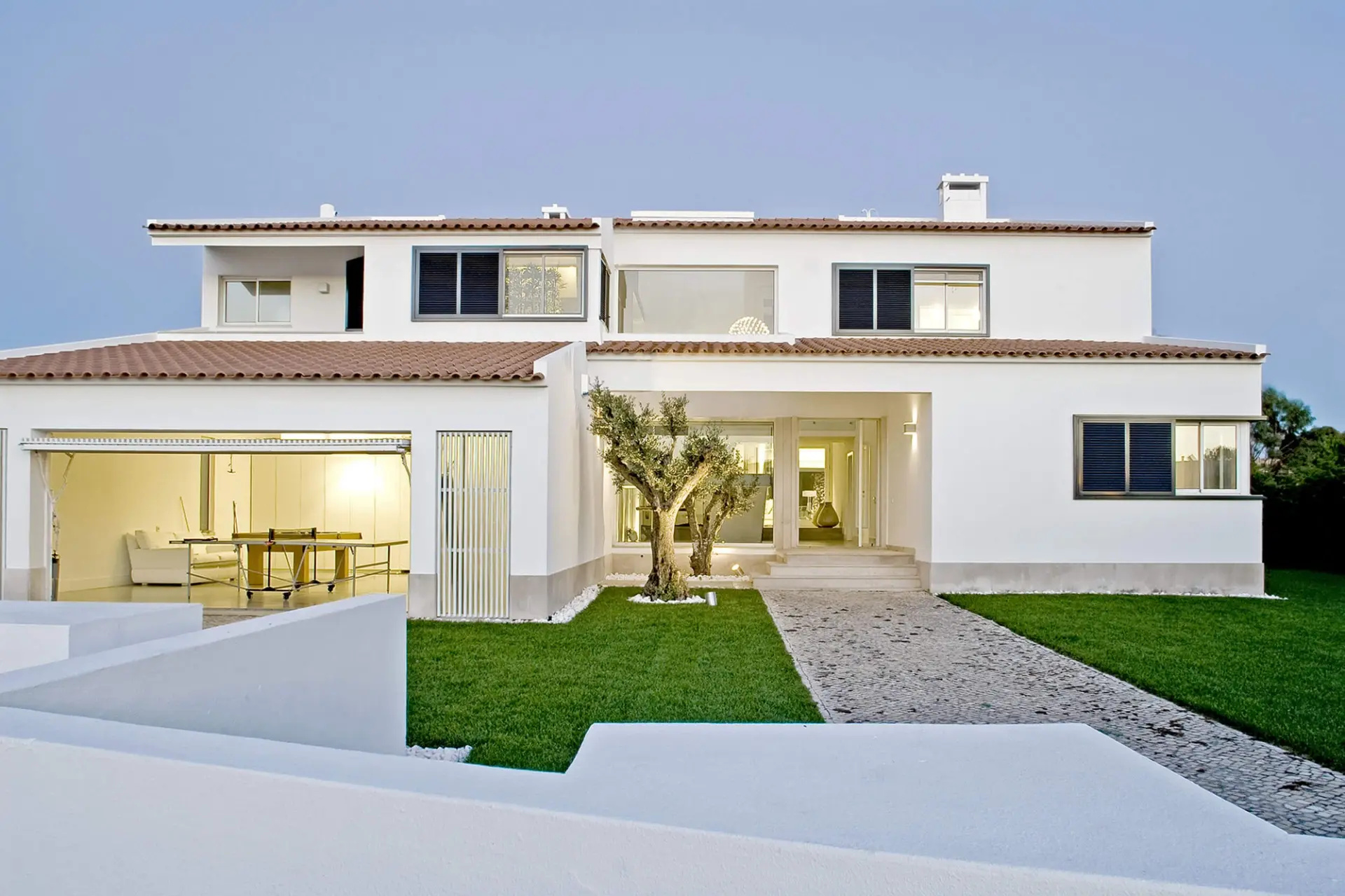 Fachada de moradia branca com telha de barro, caminho em calçada e relvado — design de interiores de luxo Tróia, Setúbal
