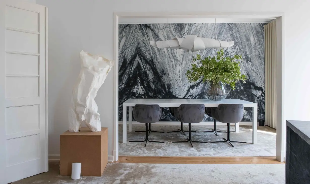 Contemporary dining room interior design project in Lisbon by Atelier Renata Santos Machado, featuring a marble statement wall, sculptural lighting and neutral furnishings.