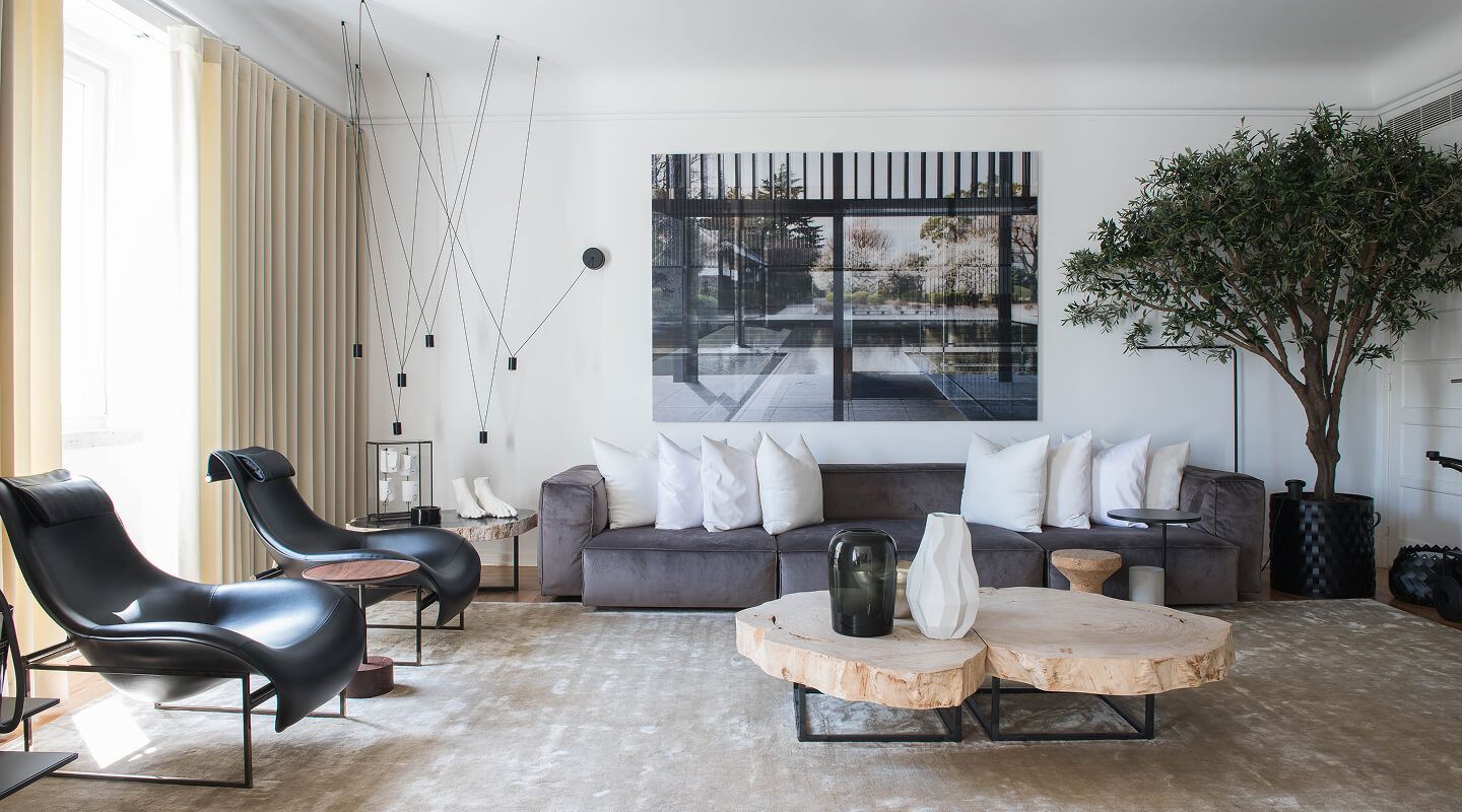 Sala de estar contemporânea com sofá em veludo cinza, cadeirão em couro preto e mesa de centro em madeira natural — projeto de design de interiores residencial premium em Lisboa, Atelier Renata Santos Machado