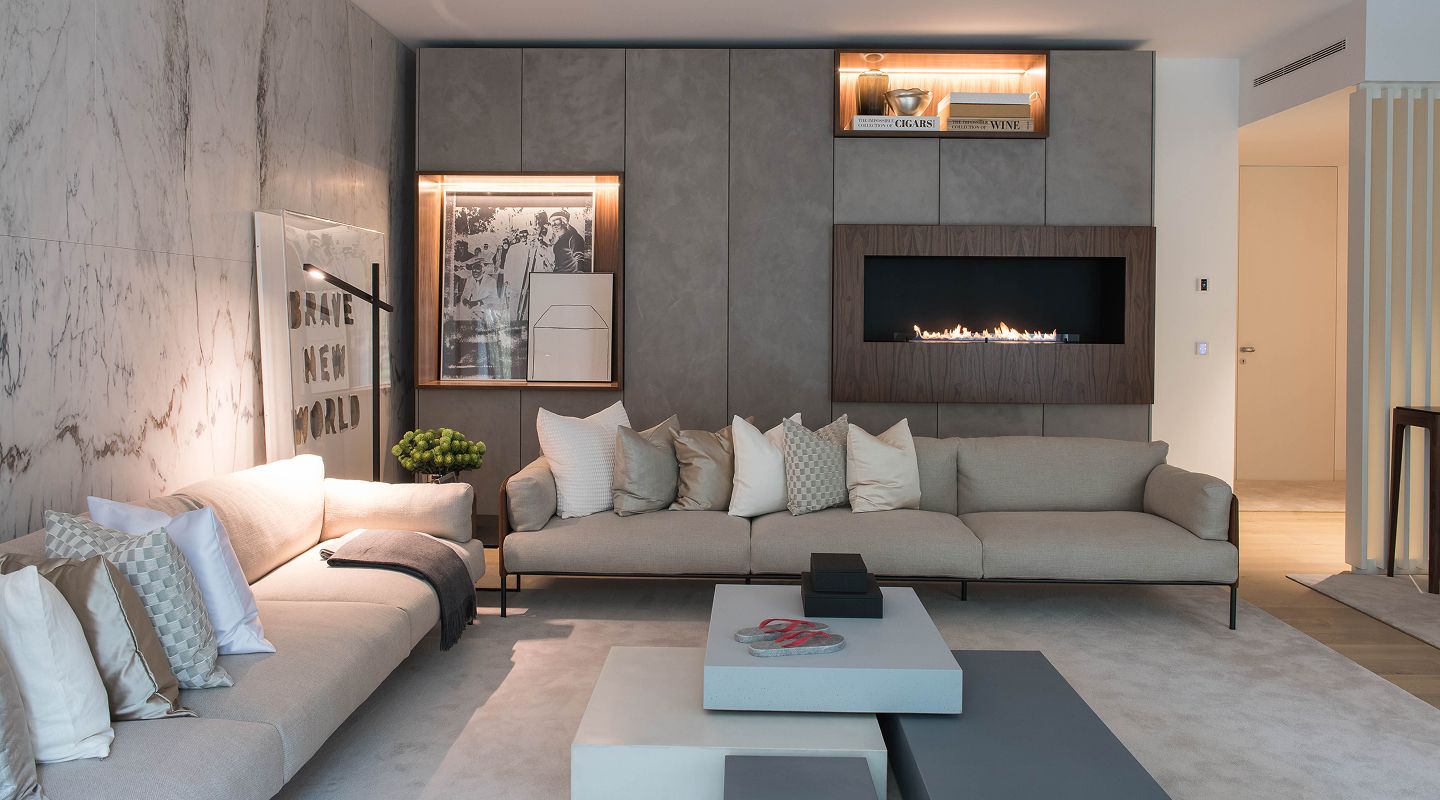 Sala de estar com parede de lareira em bioetanol embutida, revestimento em microcimento e nichos em nogueira — design de interiores de luxo em Lisboa, Atelier Renata Santos Machado