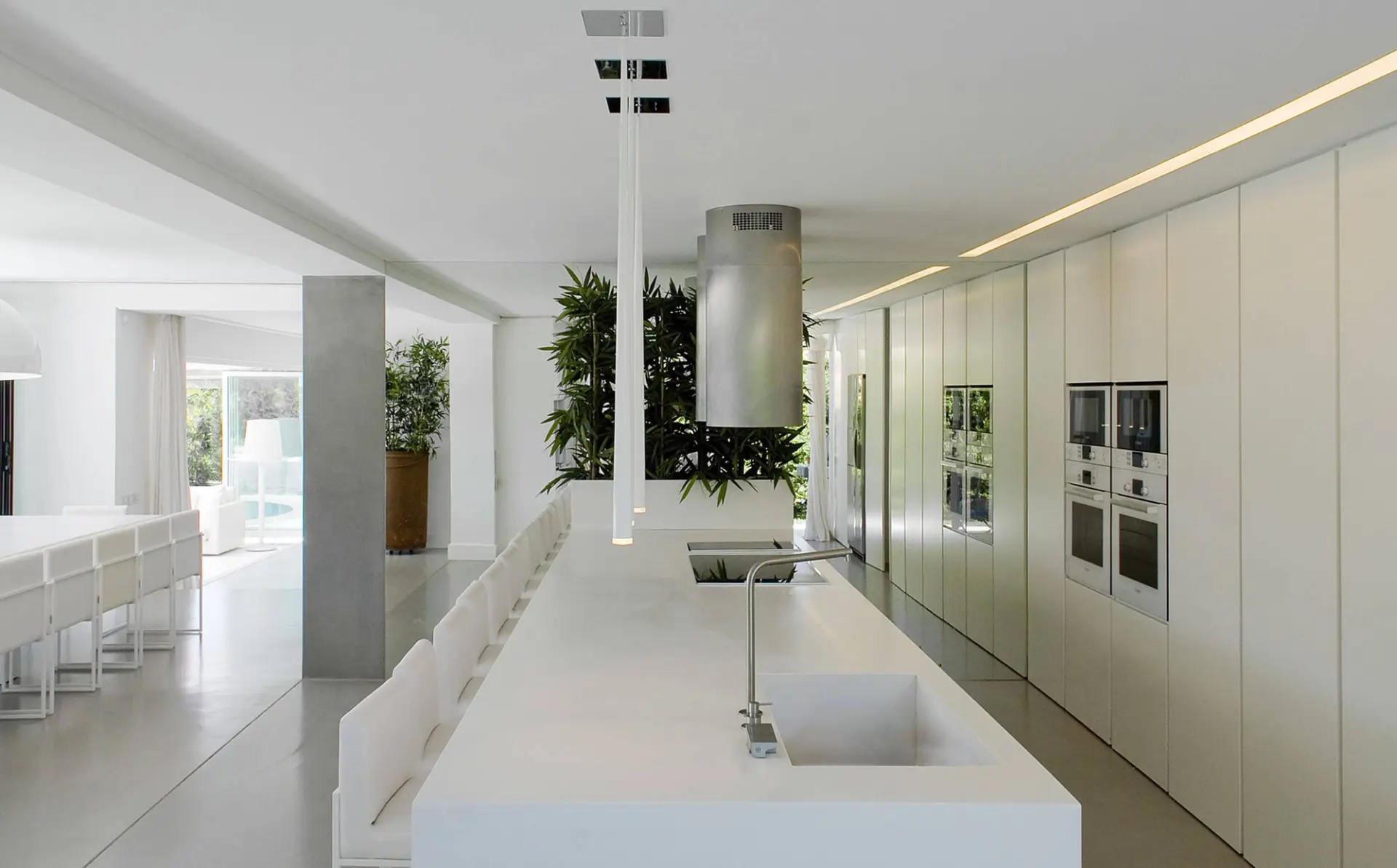Cozinha branca com ilha, exaustor cilíndrico em inox e armários sem puxadores — design de interiores de luxo Tróia, Setúbal