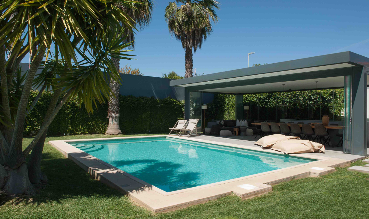 Outdoor living area with pool, integrated seating and a seamless connection between interior and exterior spaces. Project by Atelier Renata Santos Machado