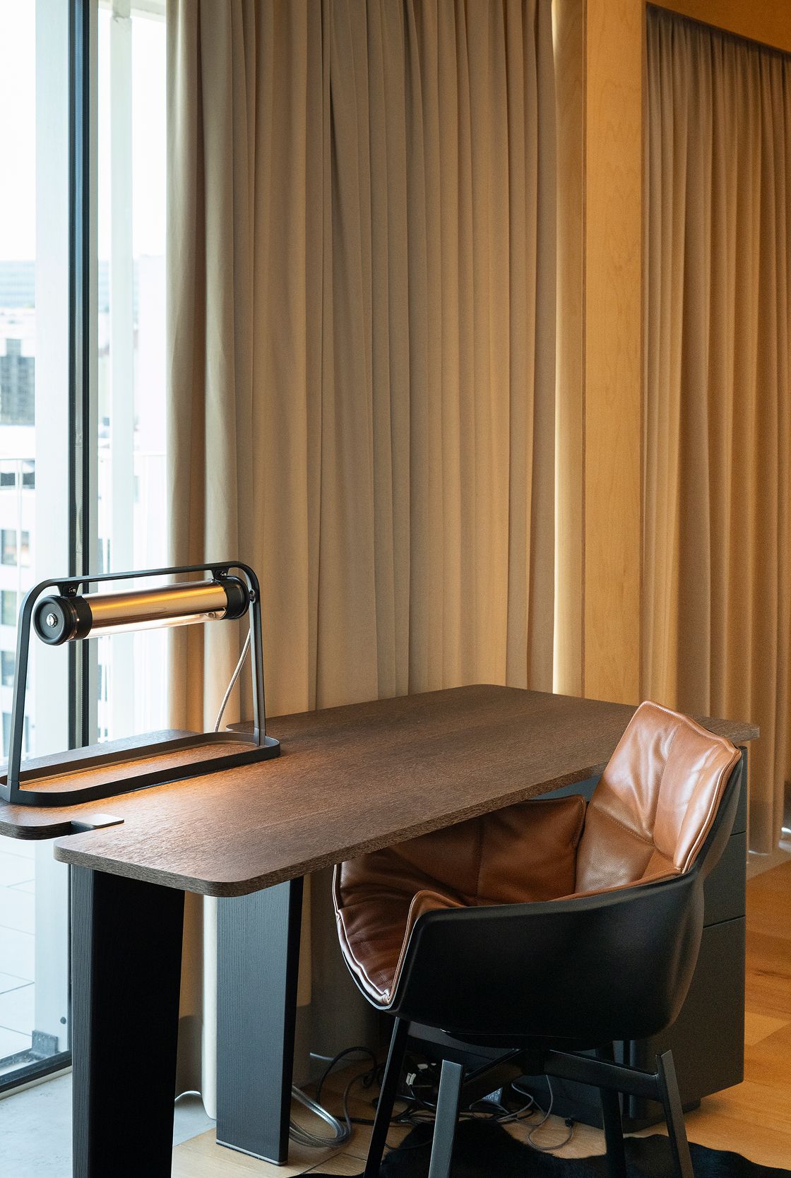 Detalhe de secretária em nogueira com candeeiro industrial e cadeira em couro cognac — design de interiores de luxo, Praça de Espanha, Lisboa, Atelier Renata Santos Machado