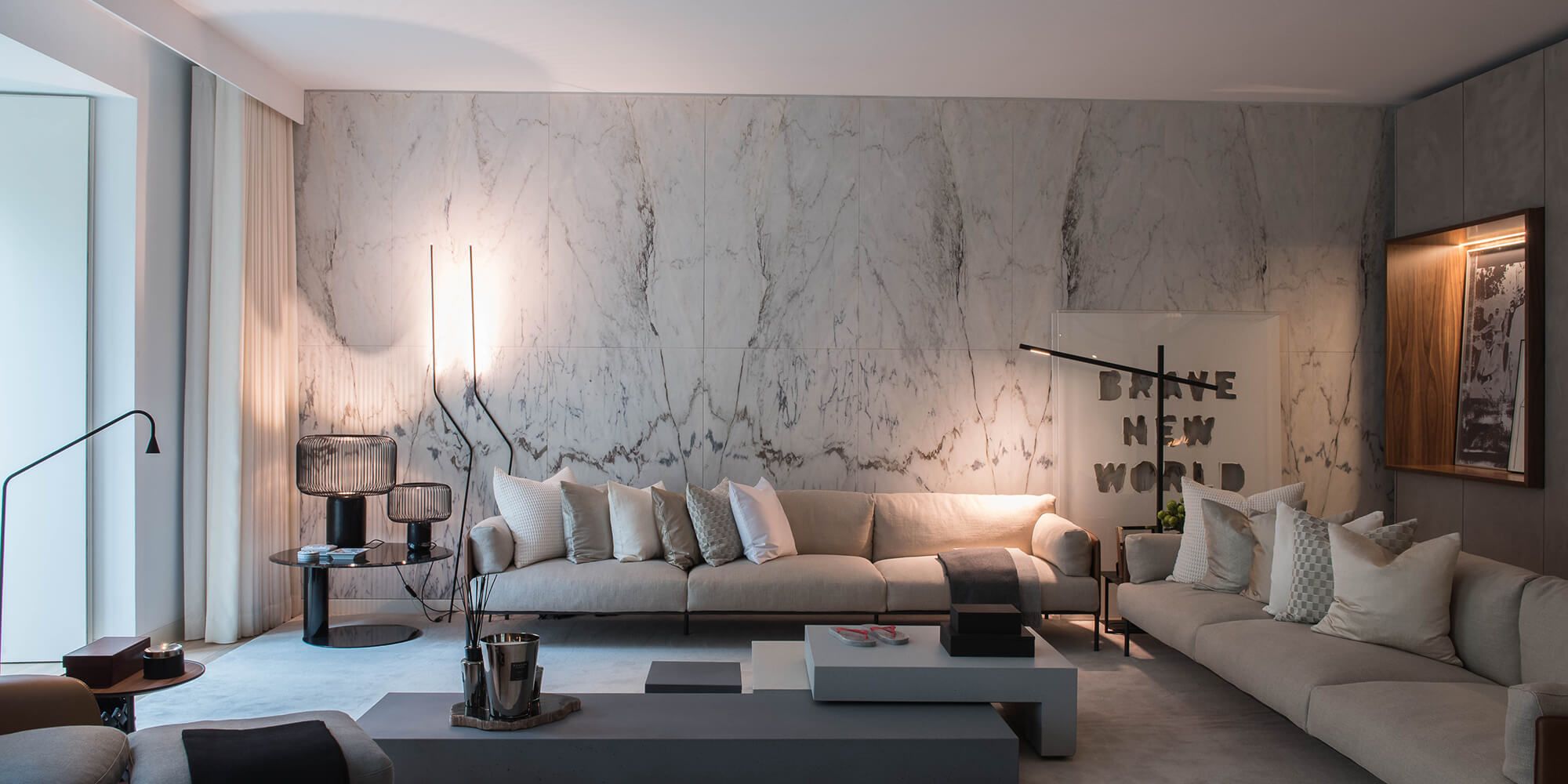Sala de estar com parede revestida a mármore em grande formato, sofás modulares e candeeiro de pé — projeto de design de interiores de luxo na Avenida da Liberdade, Lisboa, Atelier Renata Santos Machado