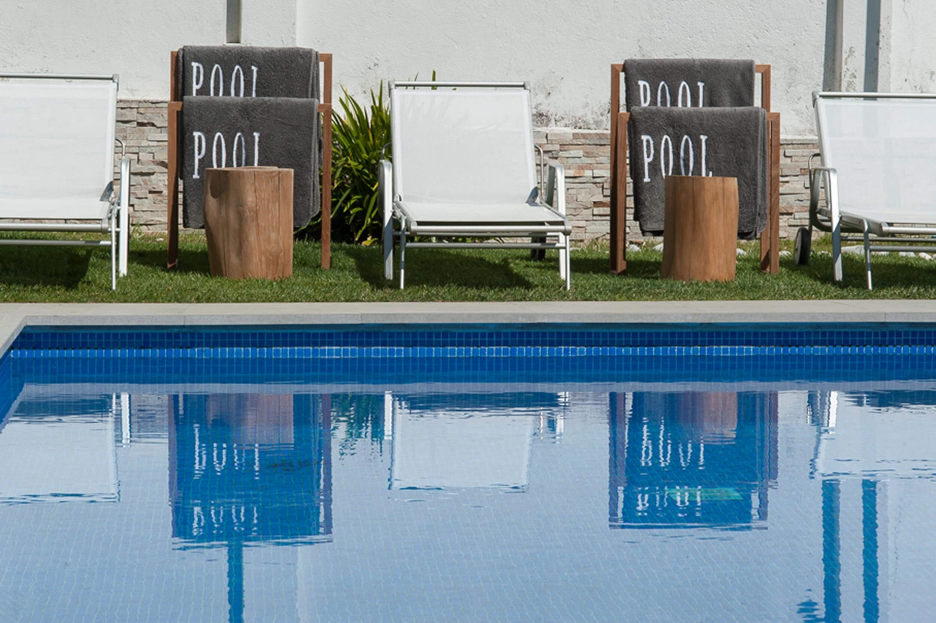 Piscina privada, espreguiçadeiras brancas, mesas Gloster LOG e parede pedra cinzenta — design de interiores de luxo Paço de Arcos, Oeiras, Atelier Renata Santos Machado