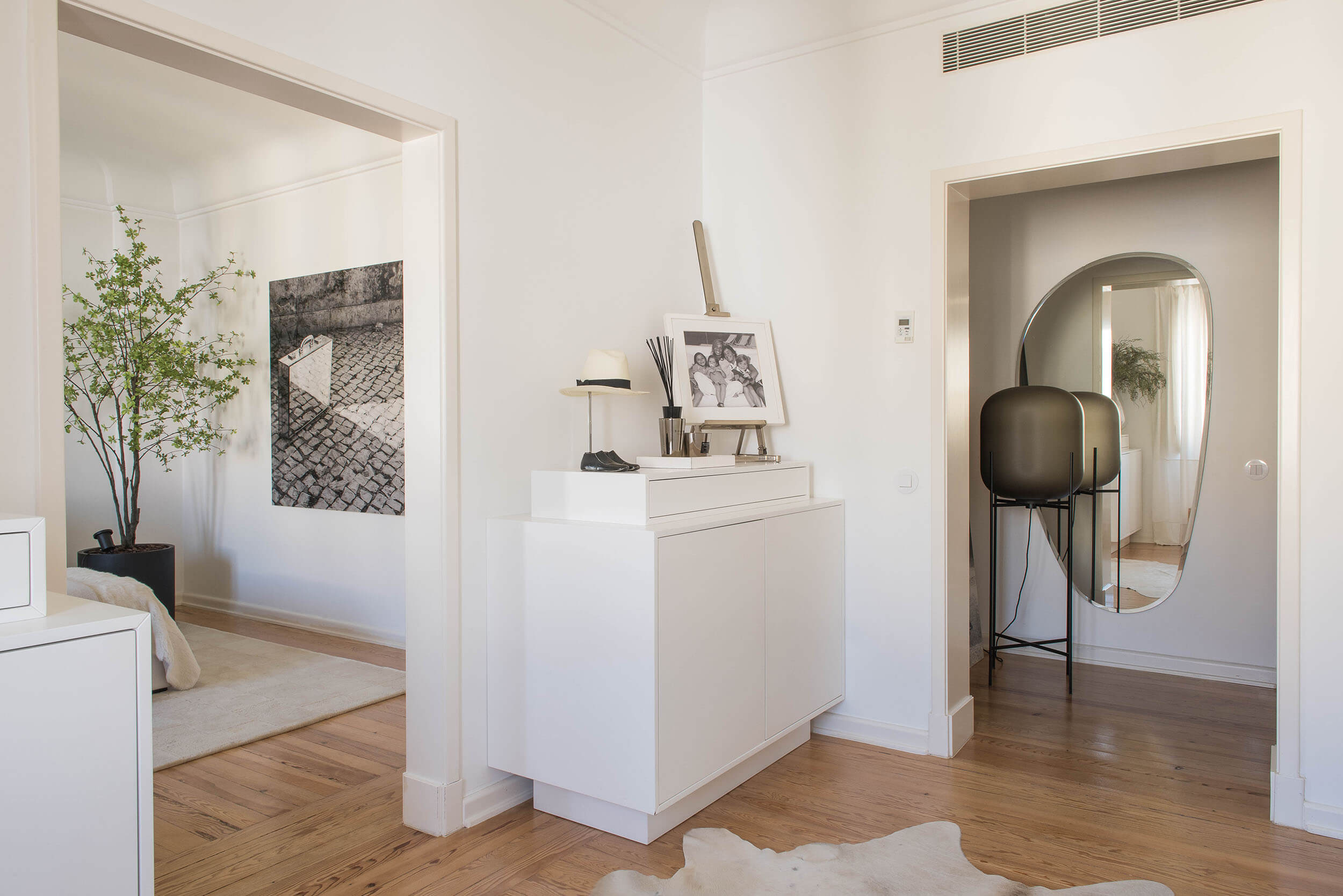 Corredor entre quarto e closet com espelho oval Cattelan Italia, candeeiro Pulpo e tapete de vaca — design de interiores de luxo, Avenidas Novas, Atelier Renata Santos Machado