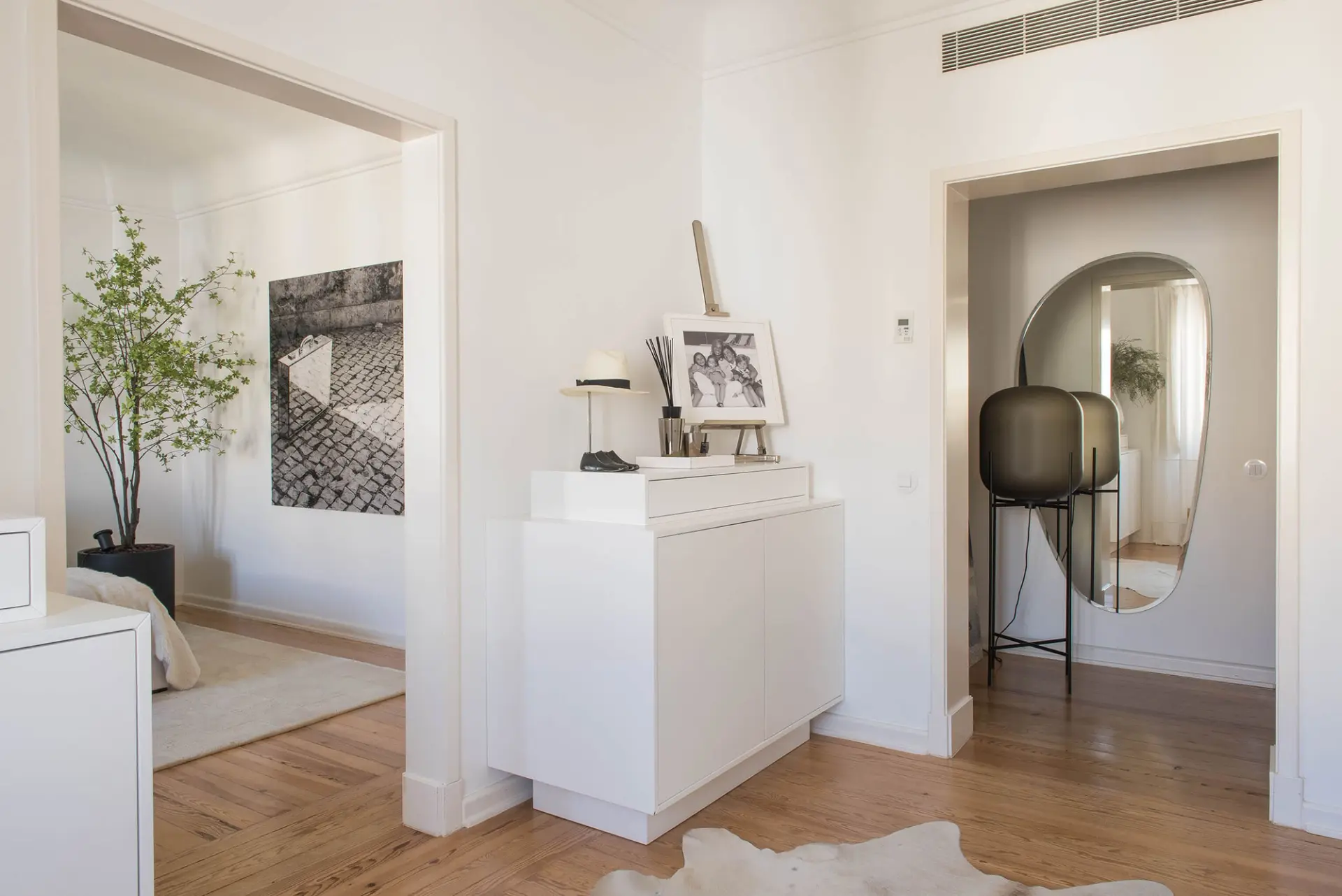 Corredor entre quarto e closet com espelho oval Cattelan Italia, candeeiro Pulpo e tapete de vaca — design de interiores de luxo, Avenidas Novas, Atelier Renata Santos Machado