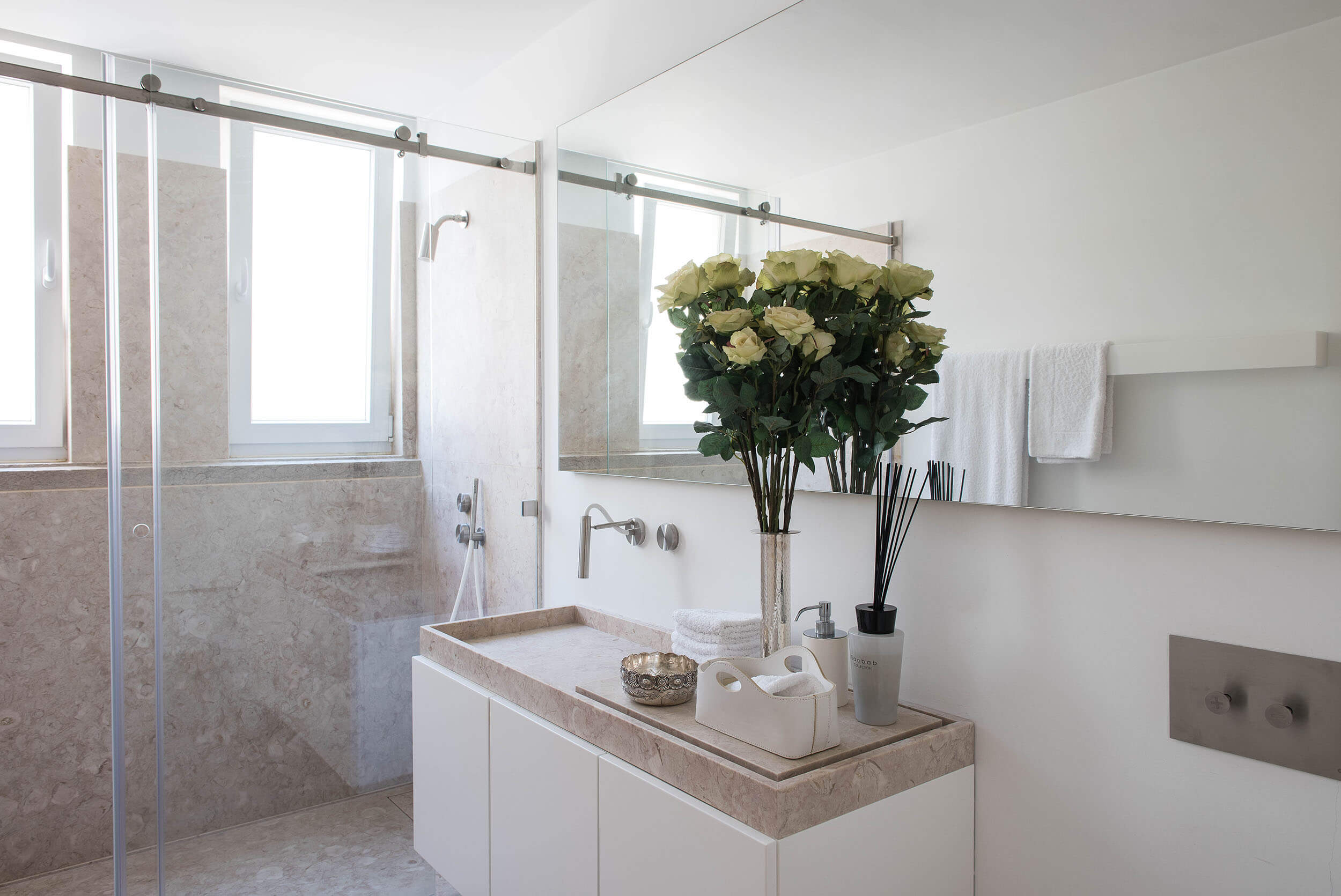 Casa de banho com bancada em pedra Lioz, torneiras CEA de parede e duche em mármore — design de interiores de luxo, Avenidas Novas, Lisboa, Atelier Renata Santos Machado