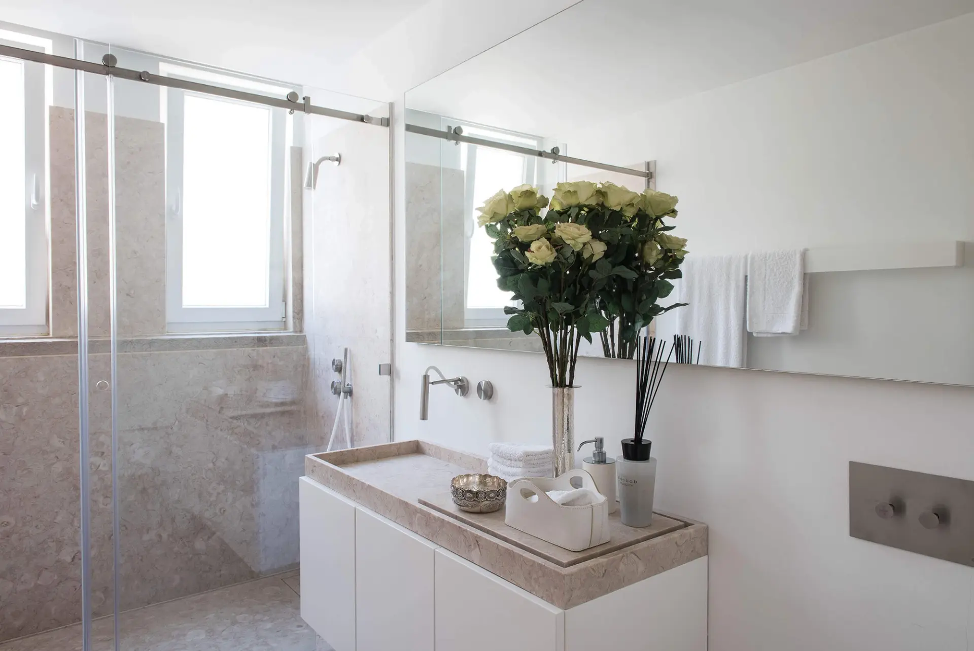 Casa de banho com bancada em pedra Lioz, torneiras CEA de parede e duche em mármore — design de interiores de luxo, Avenidas Novas, Lisboa, Atelier Renata Santos Machado