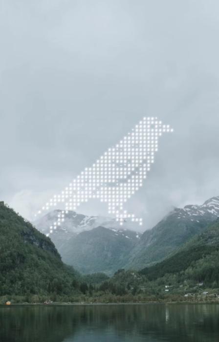 Grafikk av en kråke på et landskapsbilde med fjell og overskyet vær