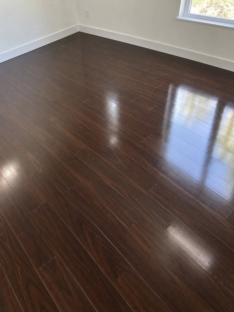 Illustration of Dark Walnut Glossed laminate in an empty room