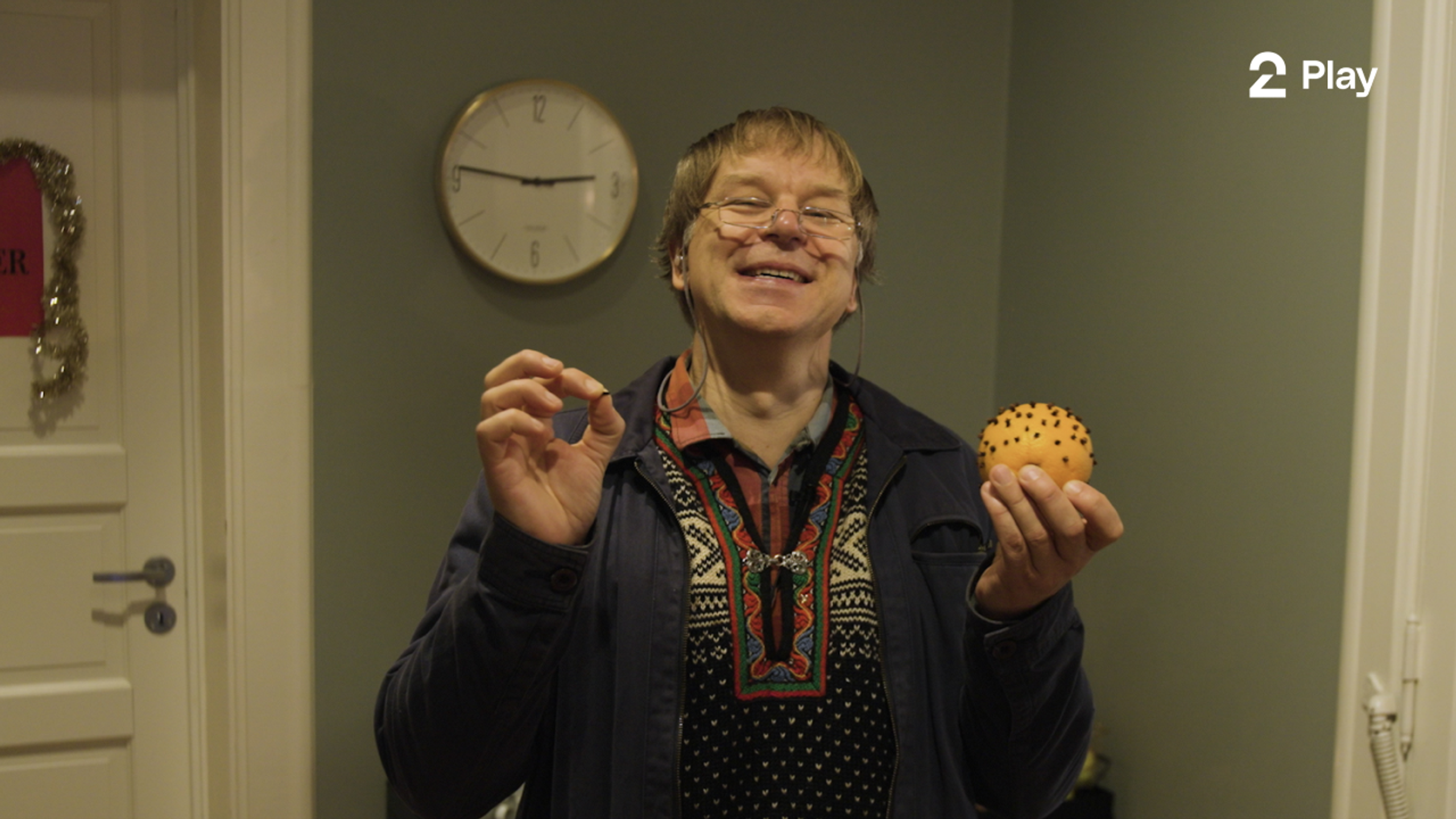 Programleder Asbjørn holder opp en appelsin med nellikspiker som sin julekalender
