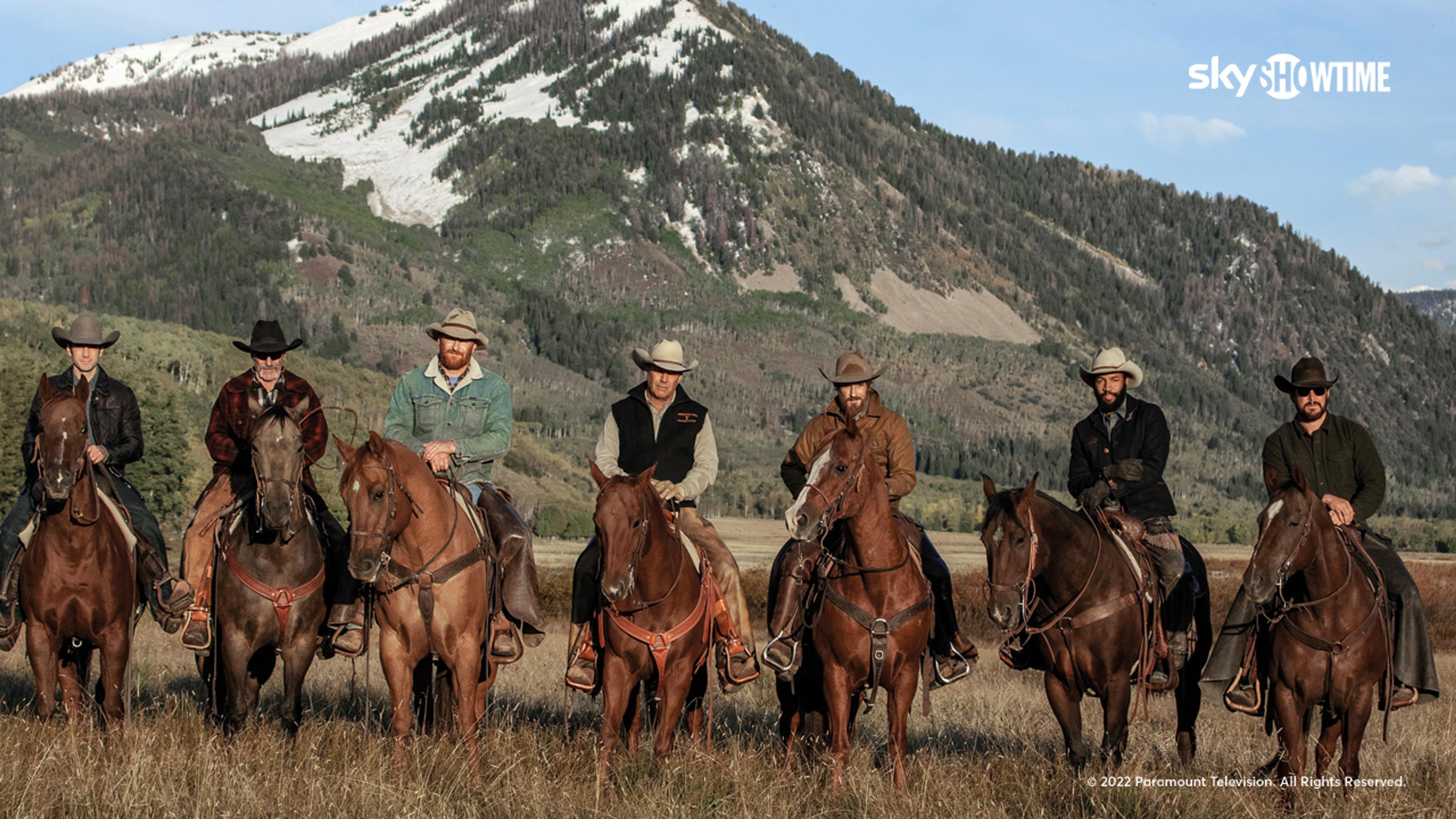 Alle cowboyene fra serien Yellowstone på hesterygg i flott amerikansk fjellandskap.