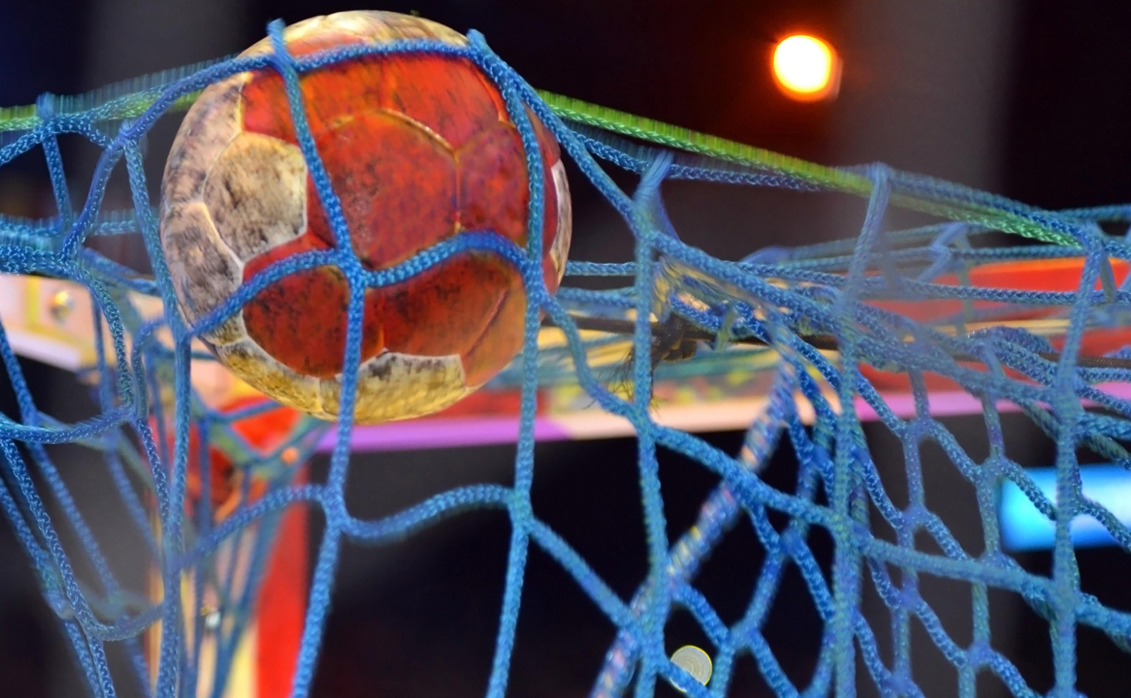 En håndball sitter klistret i målnettet tett opp mot stanga.