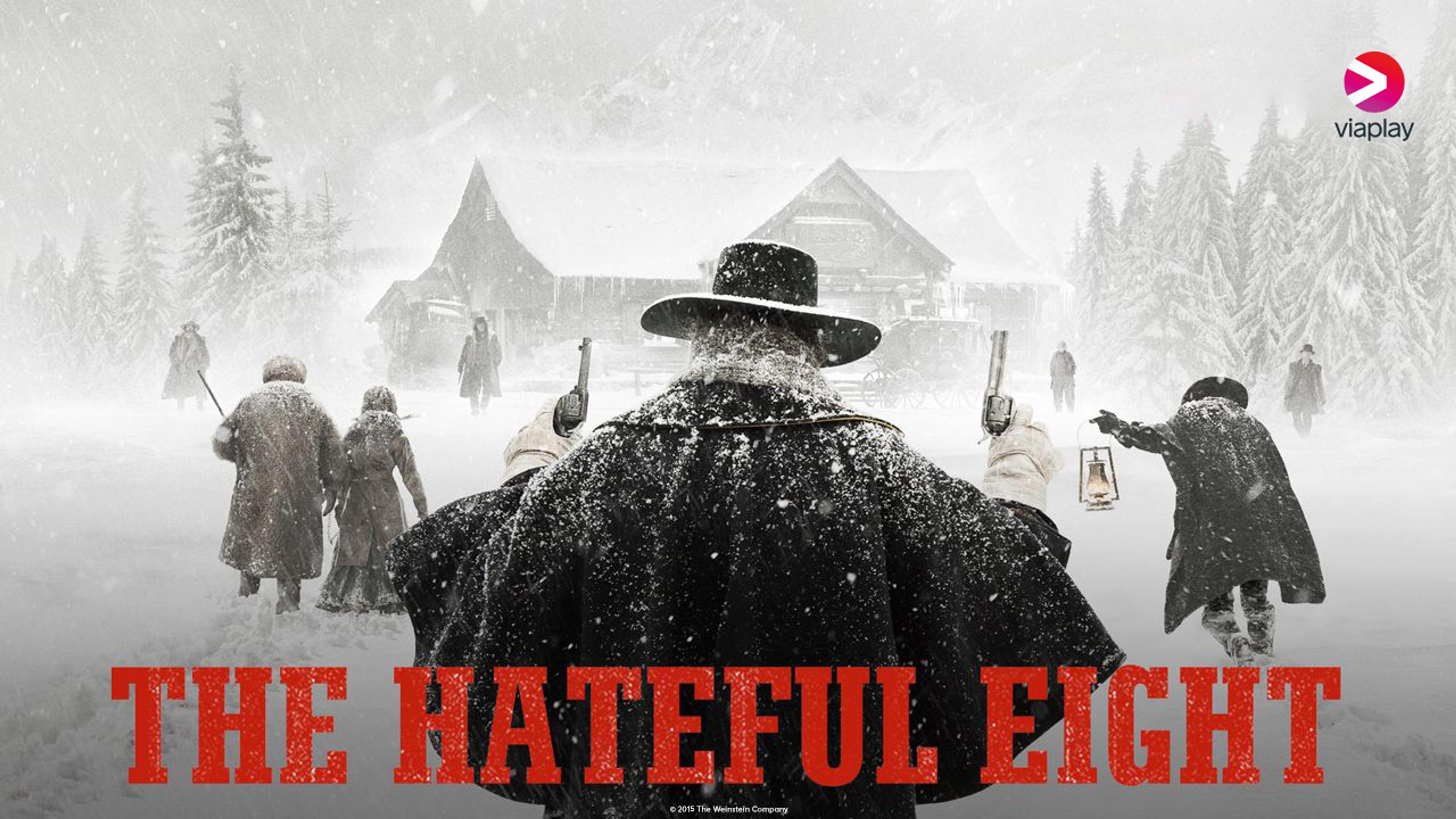 Syv siluetter av bevæpnet cowboyer går mot et hus i ødemarken i full snøstorm.