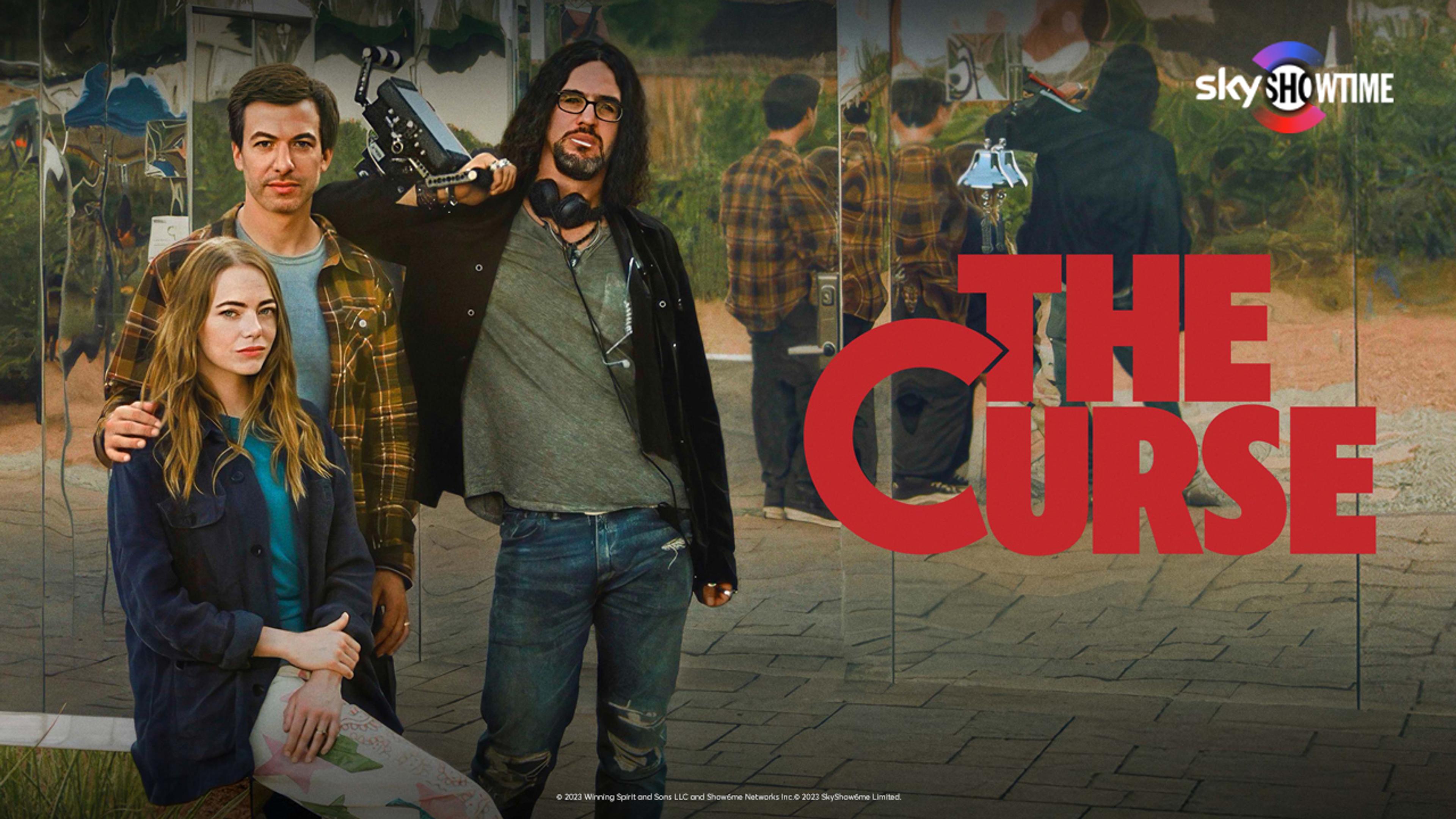 To menn og en kvinne står med et kamera med en speilvegg bak dem.