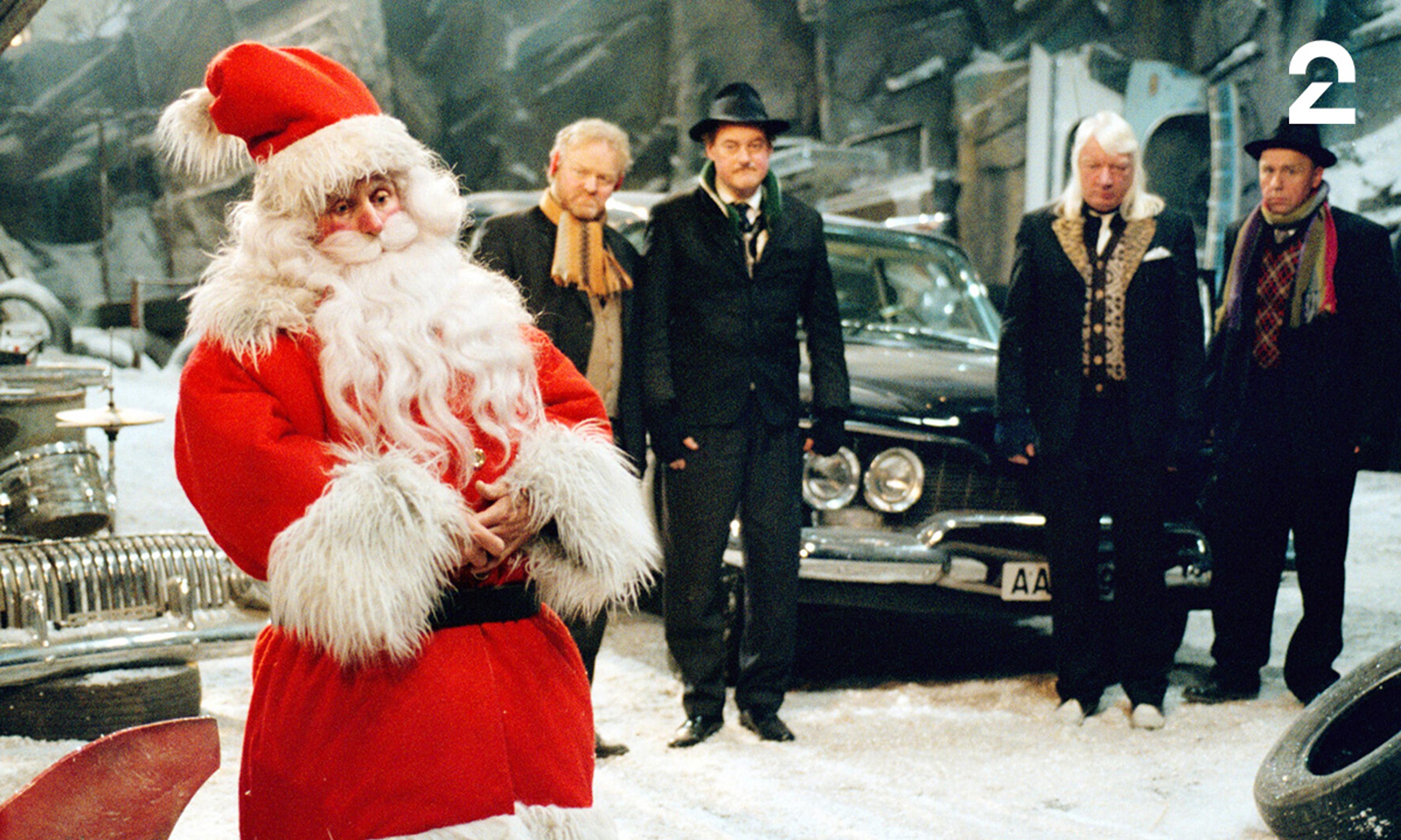 Medlemmene av Vazelina Bilopphøggers står i bilopphøggeriet og snakker med julenissen i full nissedrakt 