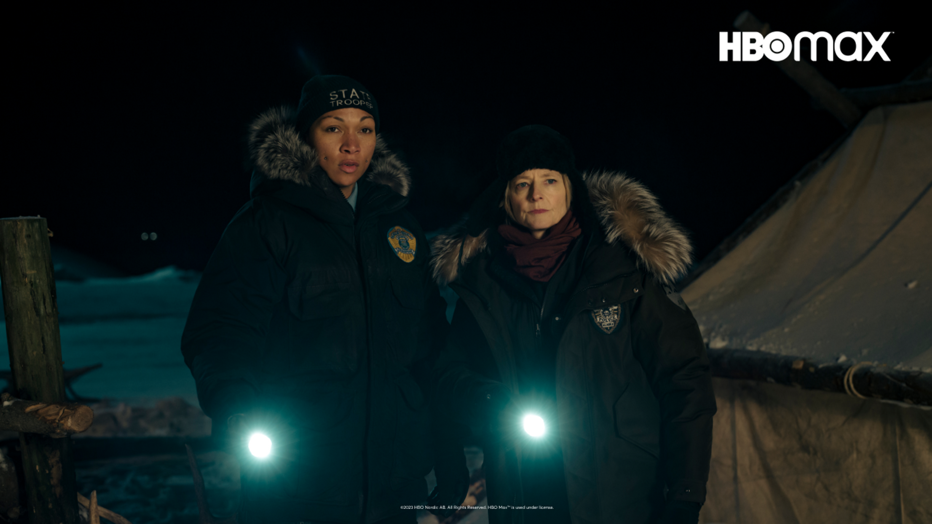 Jodie Foster og Kali Reis ser inn i kamera med to lommelykter lysende mot kamera