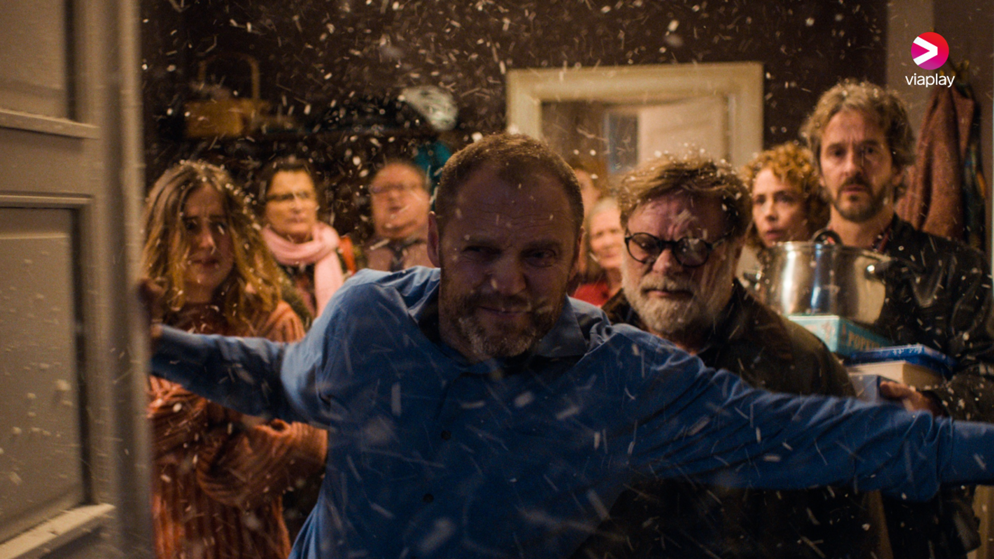 Et hus fullt av julegjester står i døråpningen til et voldsomt snøvær