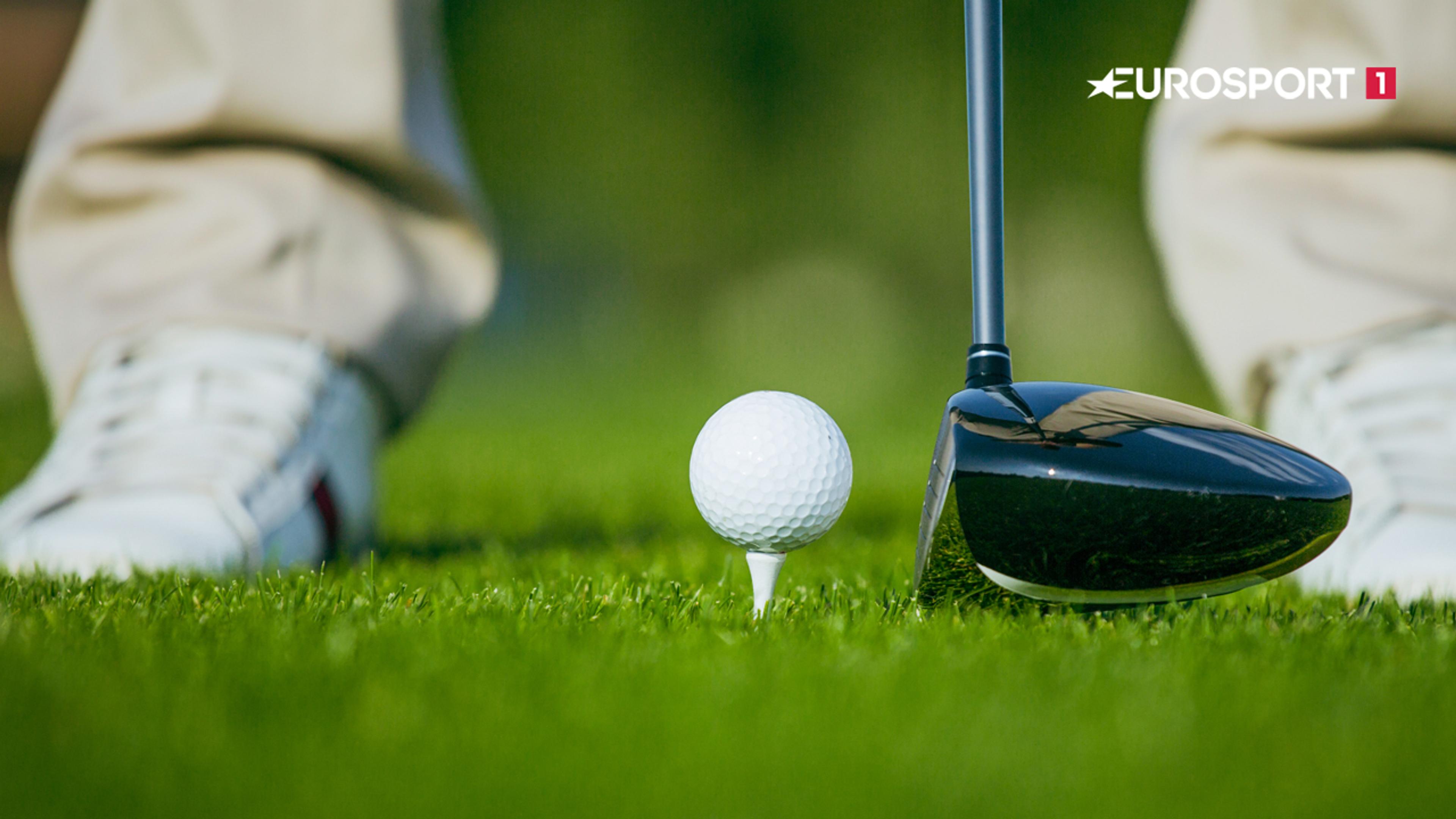 Golfspiller klar til å spille neste slag. Bilde av greenen med kølle og mann i bakgrunn.