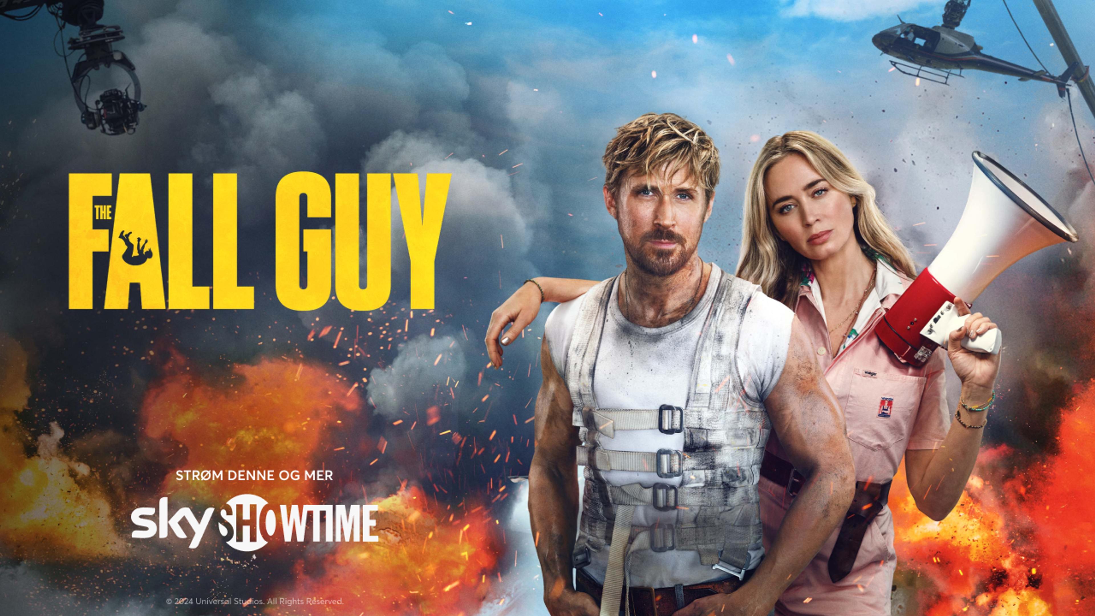 En mann og en kvinne står tett ved siden av hverandre mens det er eksplosjoner og helikoptere i bakgrunnen.