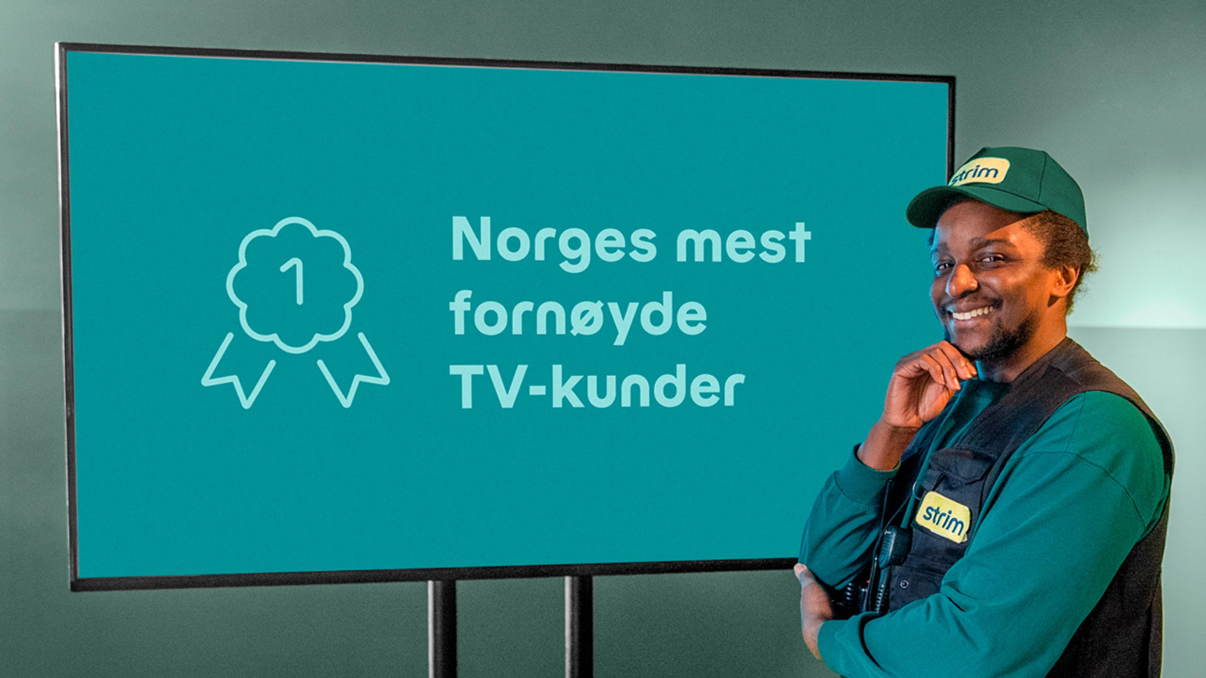 Mann står foran skjerm med skriften Norges mest fornøyde TV-kunder på.
