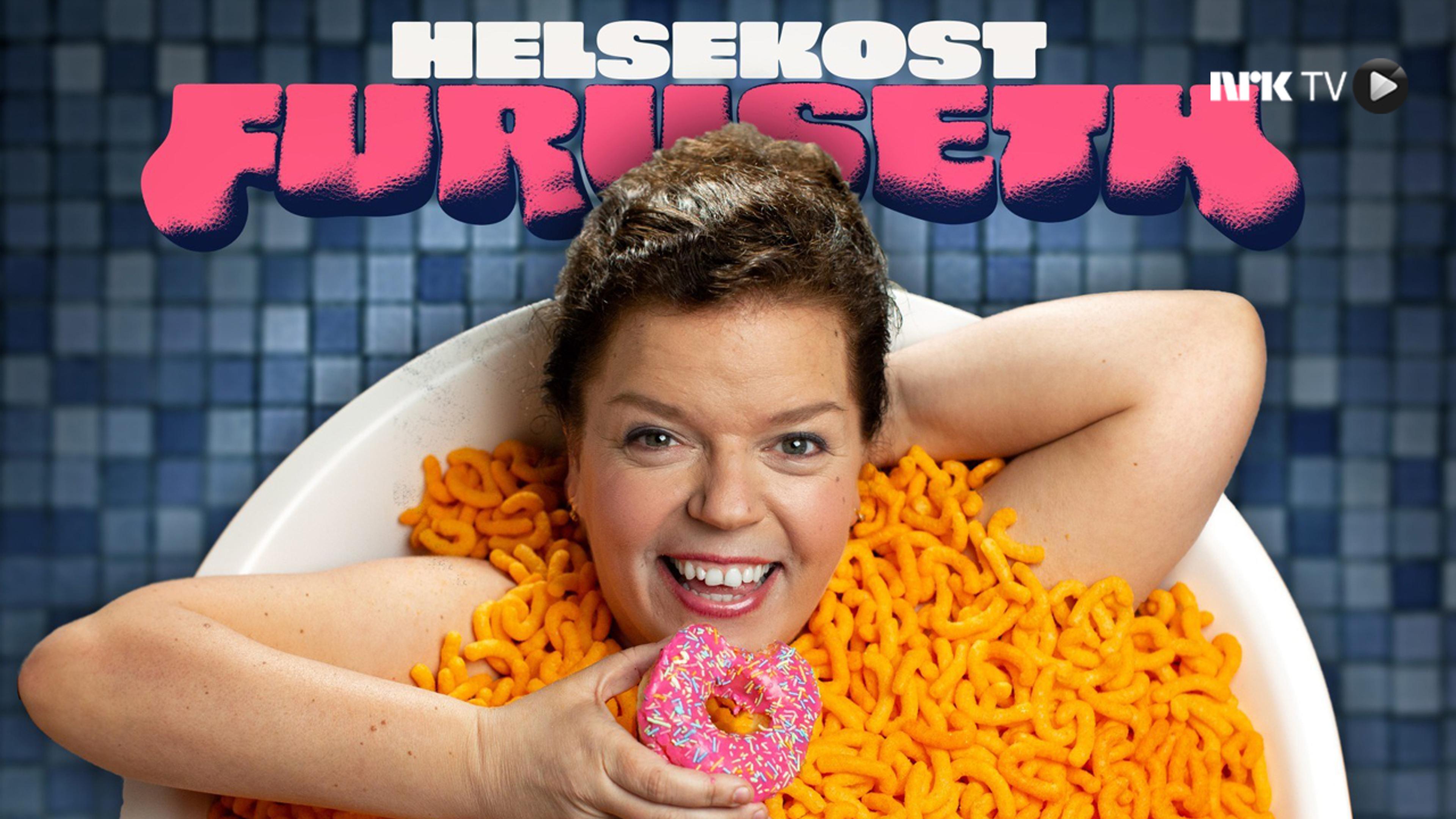 Else Kåss Furuseth ser mot kamera mens hun ligger i et badekar full av ostepop med en smultering i hånda.