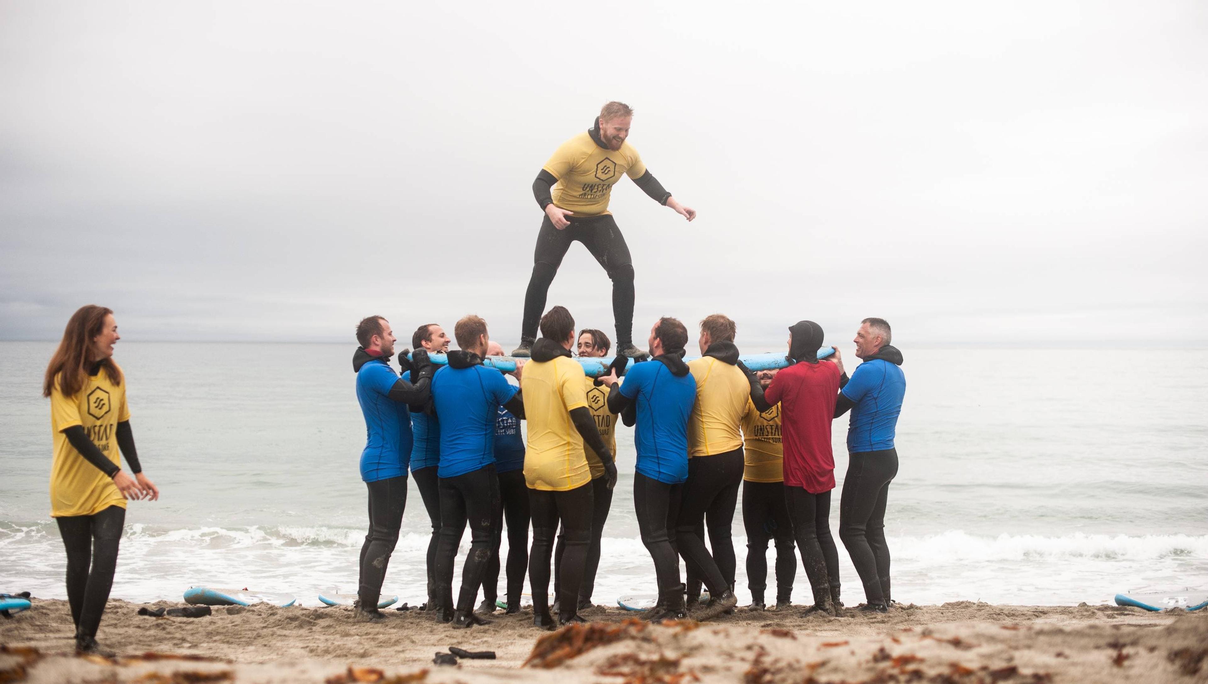 Mennesker som leker med et surfebrett på en strand