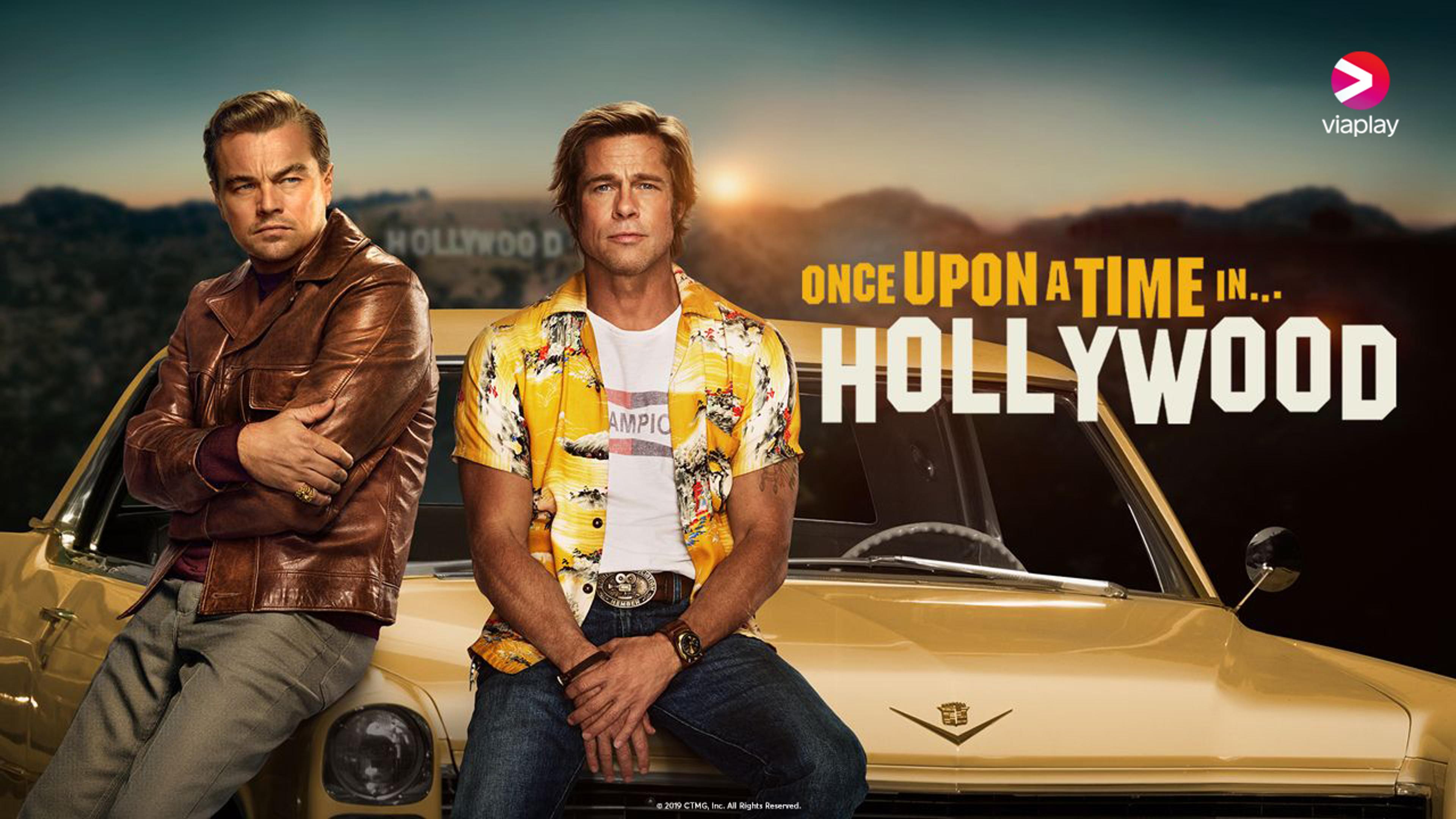 DiCaprio og Pitt sitter på panseret til en gul sportsbil med Hollywood Hills i bakgrunnen.