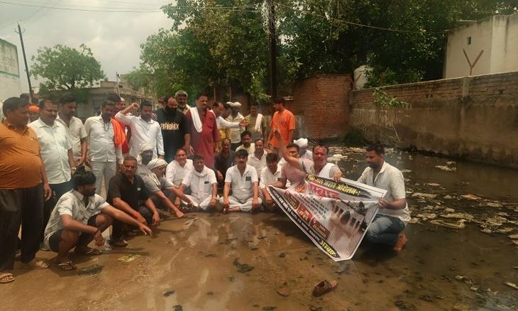 हीरो माता मंदिर मार्ग पर जलभराव: भक्तों ने गंदे पानी में बैठकर किया प्रदर्शन
