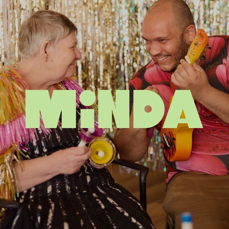 Minda campaign artwork featuring two people celebrating together with bold green Minda branding.