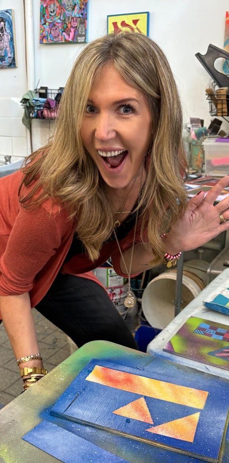 Kylie standing over her creative painting of the Fuller 'F'