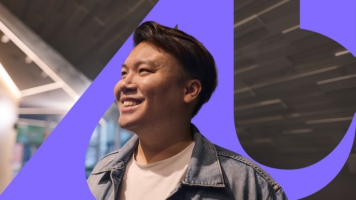 person smiling in front of the Adelaide University logo