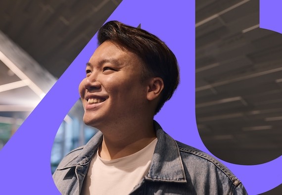 person smiling in front of the Adelaide University logo
