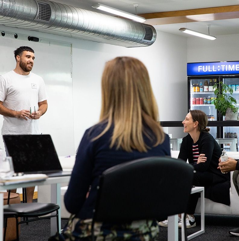 A group of people in an open room talking