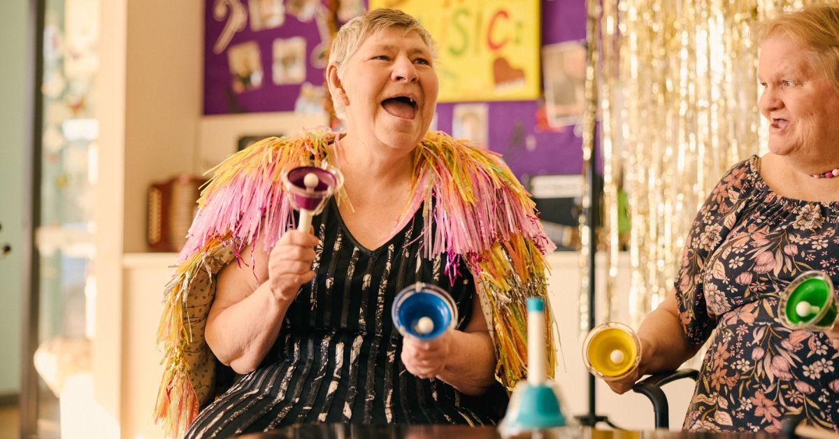 Person celebrating with colourful bells and party decorations in Minda campaign photography.