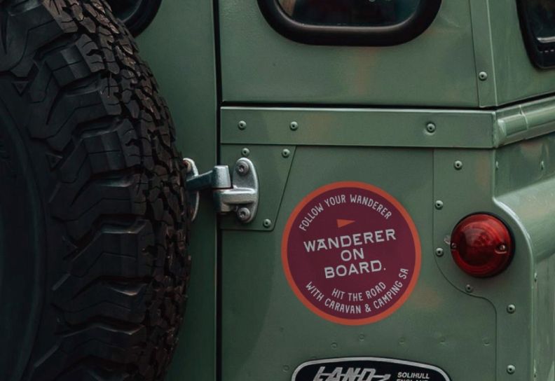 The Follow your wanderer campaign sticker on the back of a green land rover