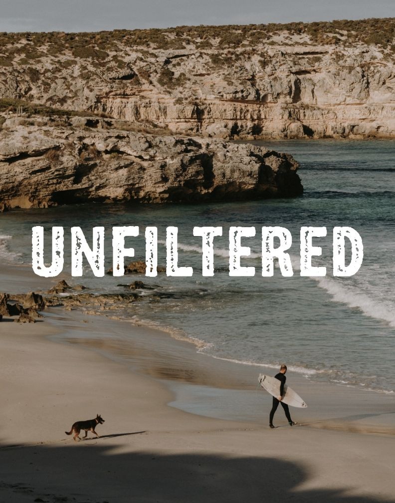 Kangaroo Island “Unfiltered” campaign hero artwork featuring a surfer and dog walking along a remote beach.