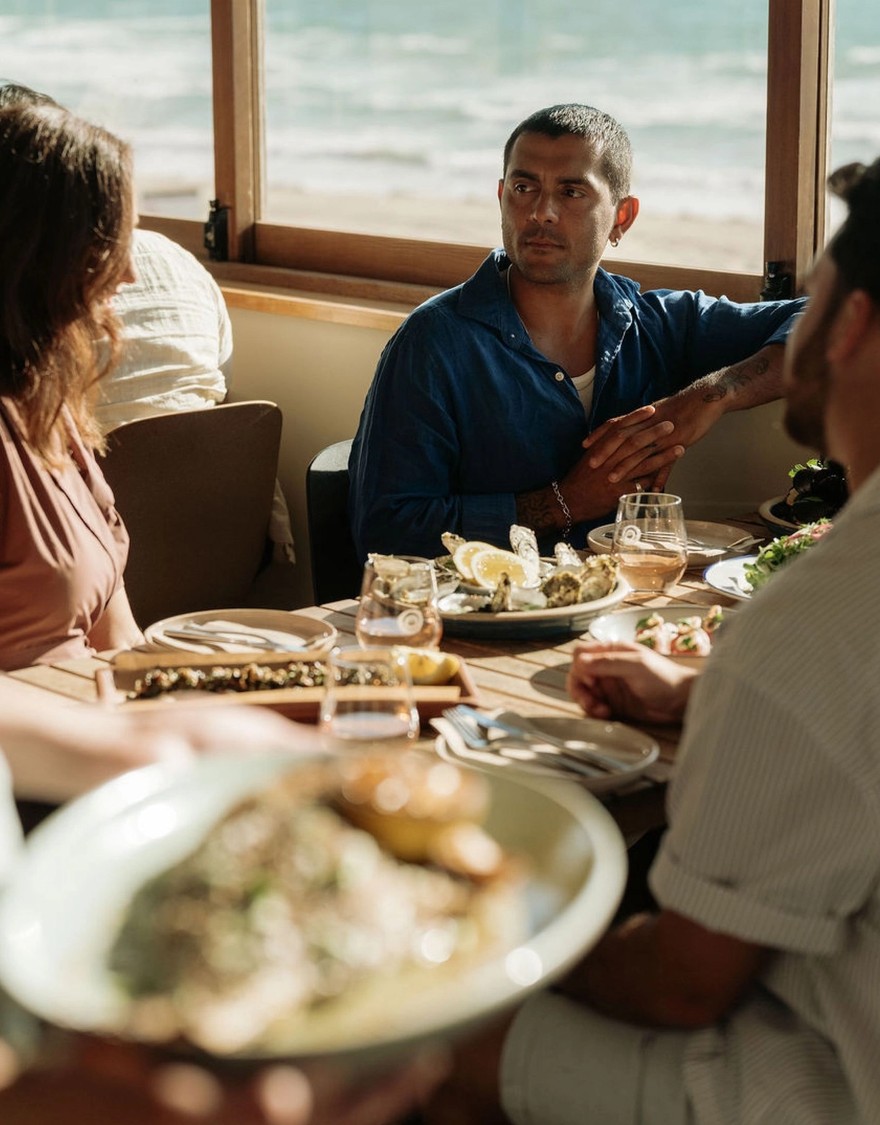 People dining at a restaurant by the beach