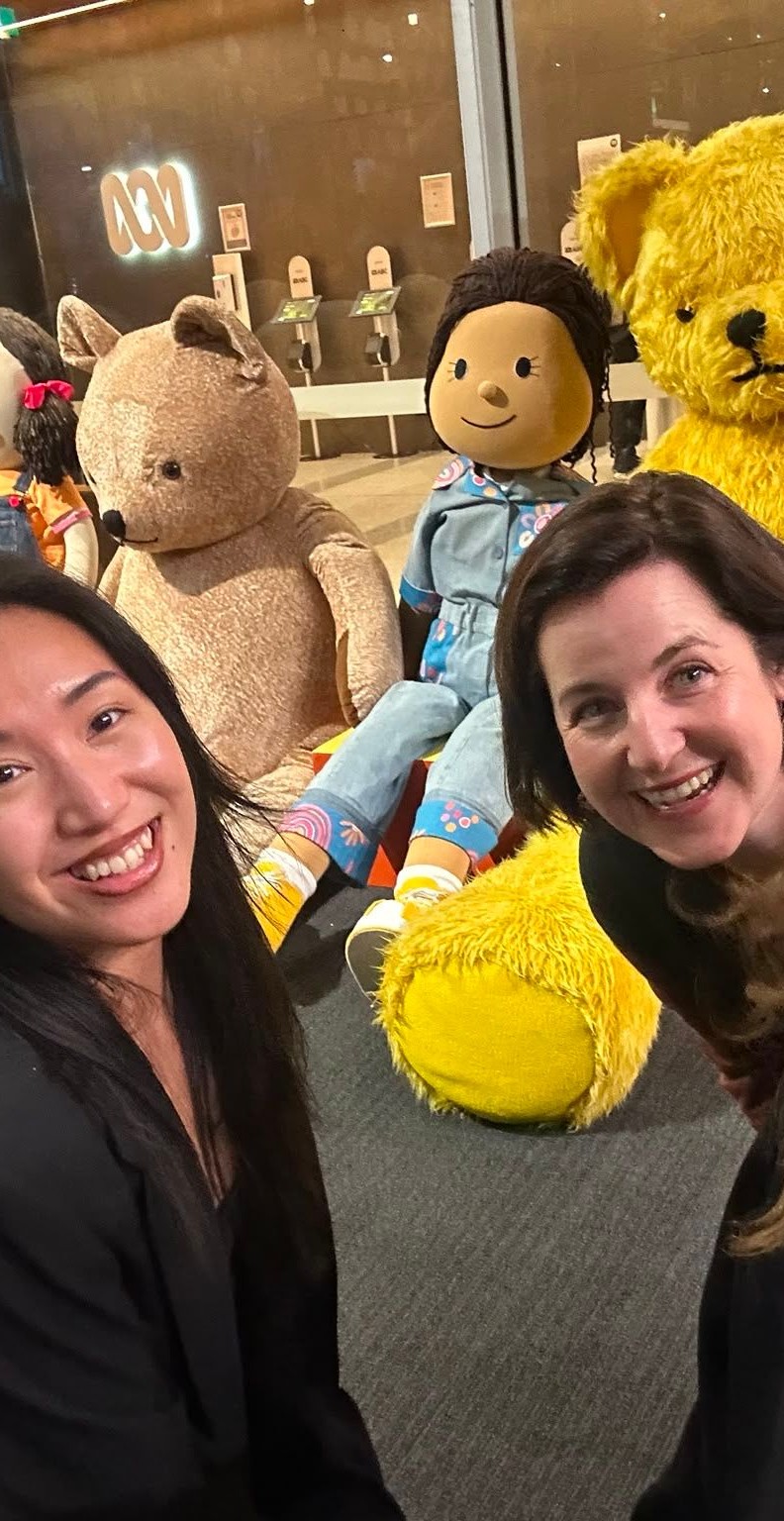 Raph, Kate and Rachael waiting in a line for Gruen surrounding by giant play school plush characters