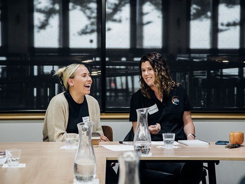Two people smiling at the table at the Eyre brand workshop